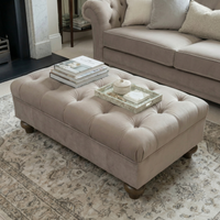 Chesterfield Velvet Footstool in Mink styled with books and a tray in a cozy living room, complete with a rug and sofa.