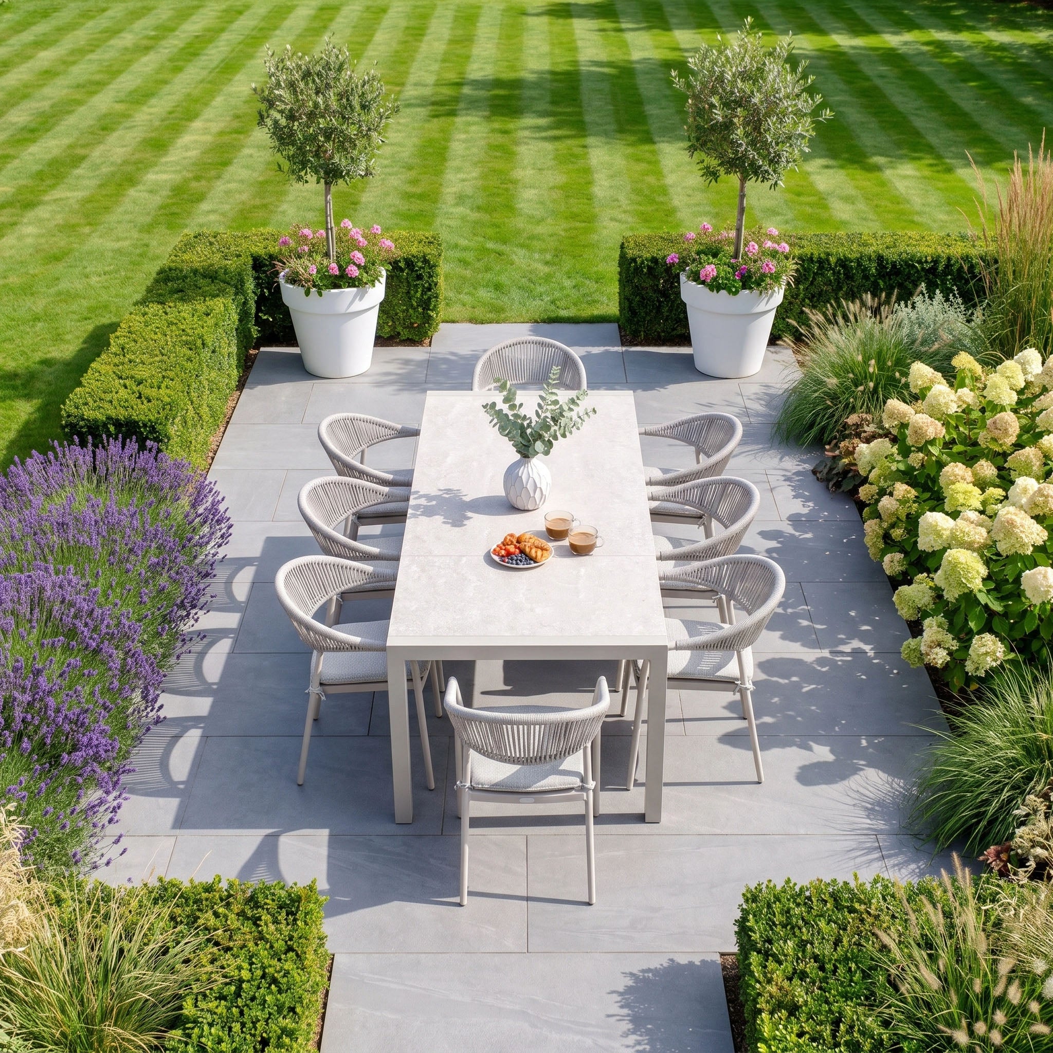 The Cloverly 8 Seat Dining Set with Ravona Extending Table in Latte, complete with eight matching chairs, creates an inviting display of contemporary outdoor patio furniture—perfectly complemented by lush green plants and a manicured lawn.