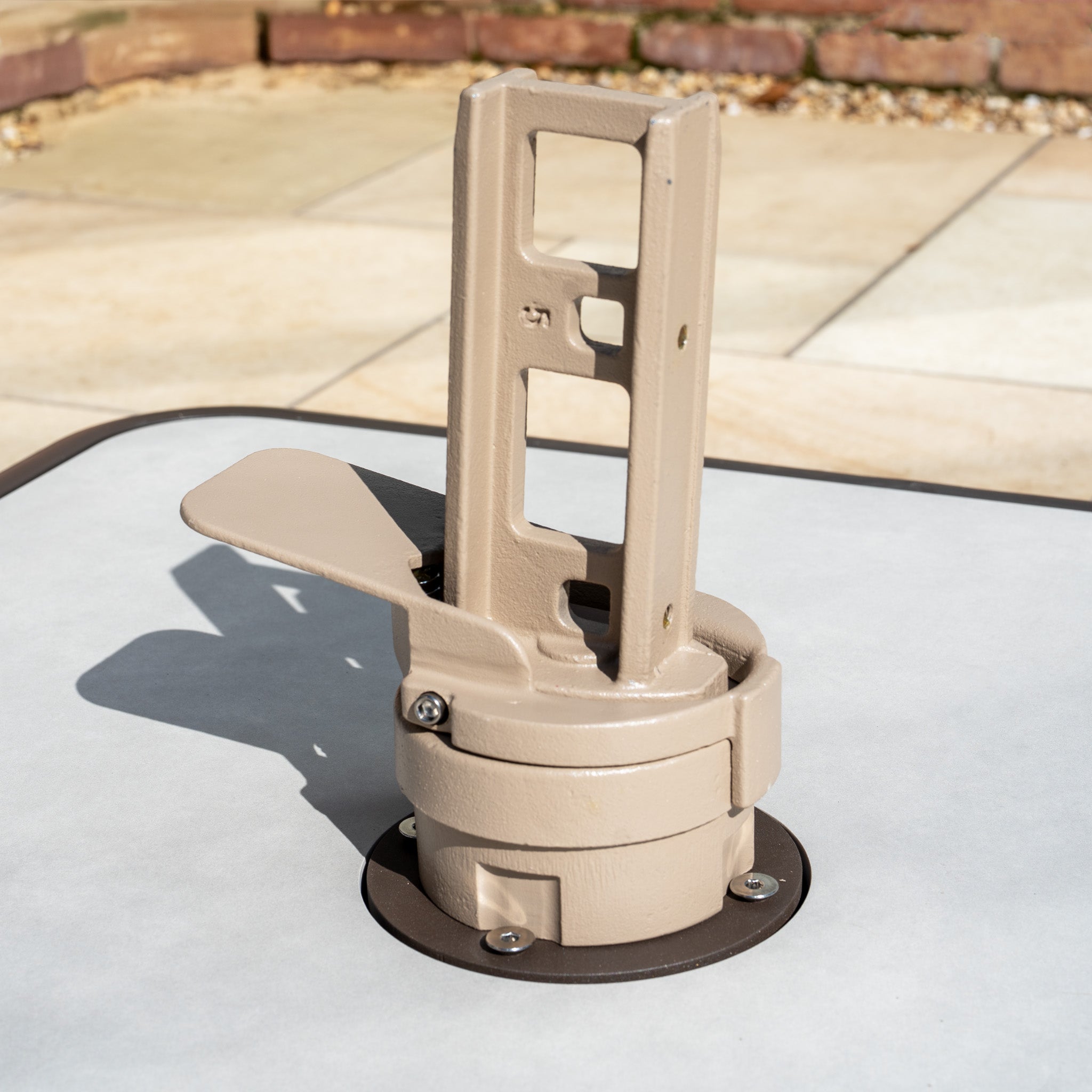 The Costa Fillable Parasol Base with Ceramic Plate, elegantly designed in beige and seamlessly mounted on a light gray patio table, elevates your outdoor space with style and sophistication.