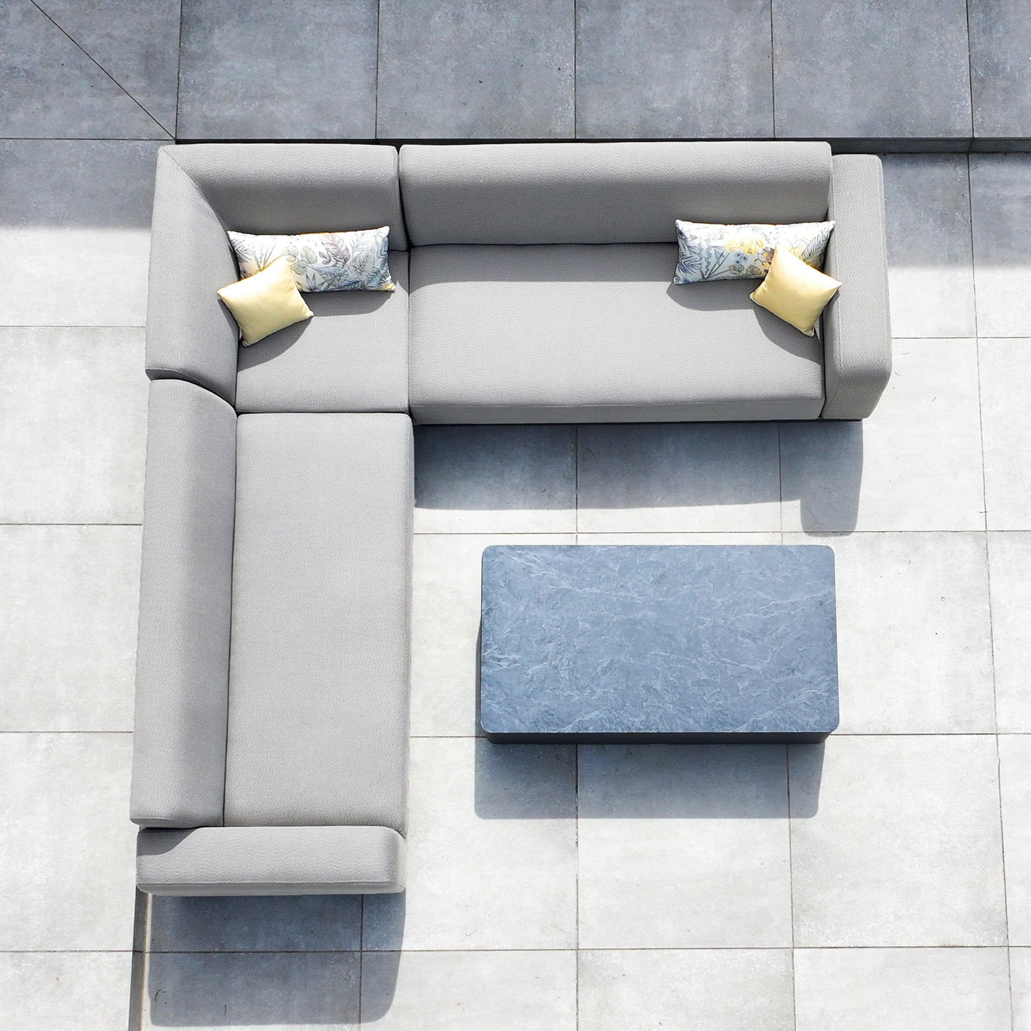 The Luna Outdoor Fabric Corner Sofa Set with Coffee Table in Oyster Grey features an L-shaped sofa with four cushions and a rectangular coffee table, perfect for all-weather garden lounging.