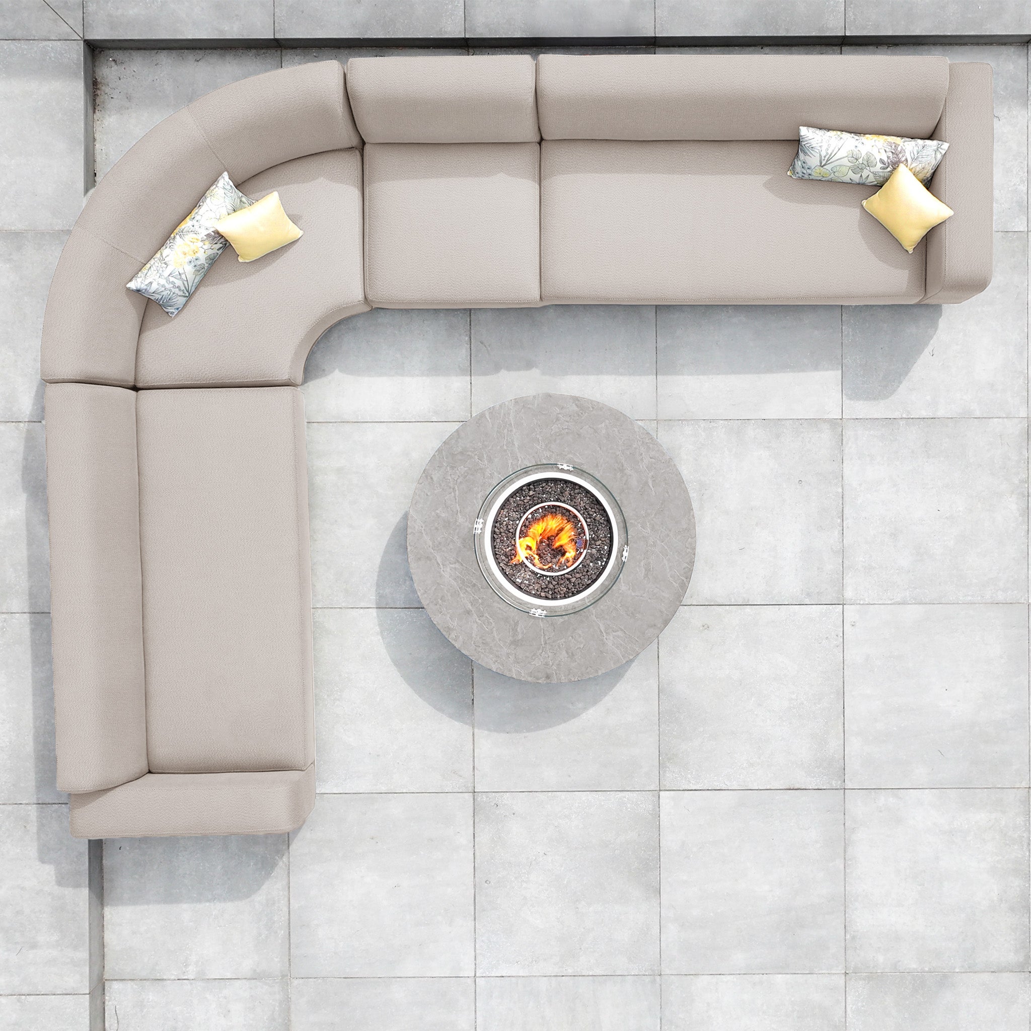 Top view of the Luna Outdoor Fabric Large Curved Corner Group Set in Fawn with pillows and a round firepit coffee table on a tiled patio.