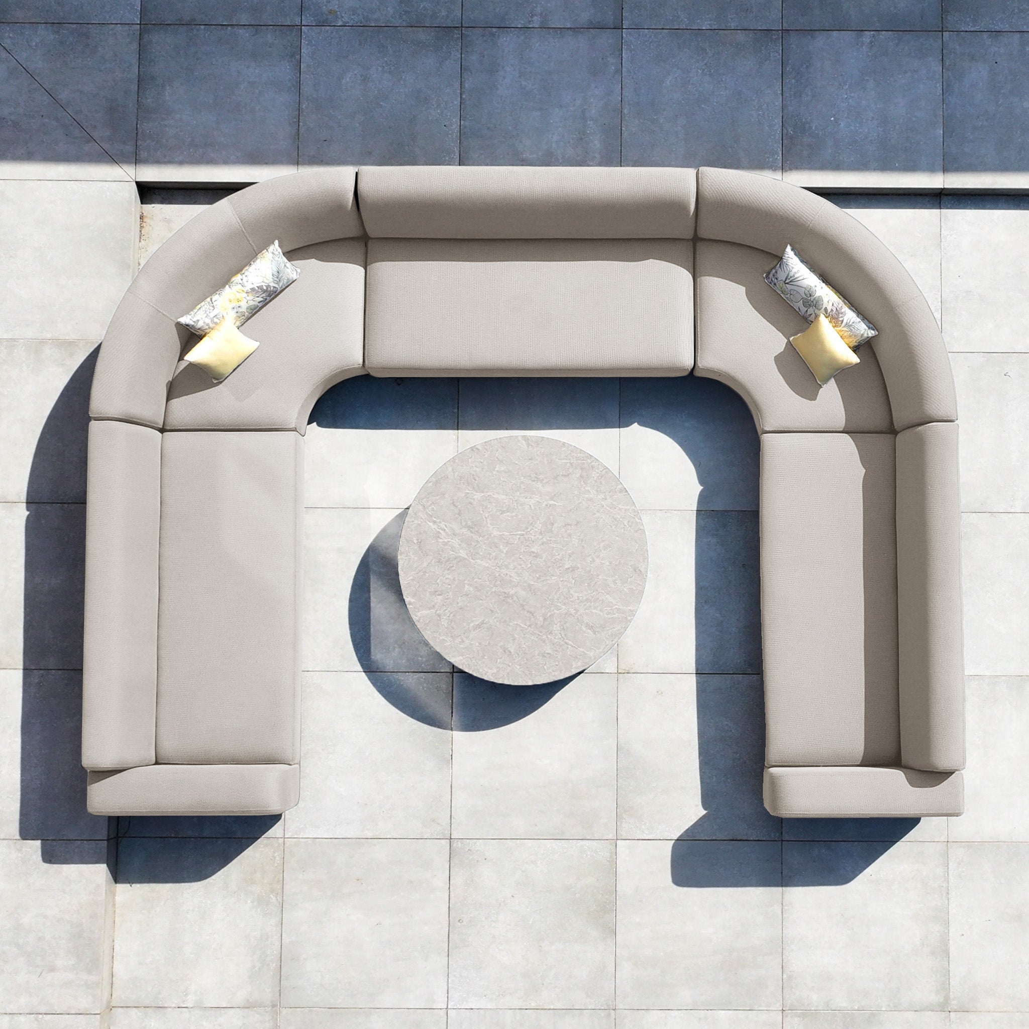 The Luna U-Shape Outdoor Fabric Curved Corner Group in Fawn features plush pillows and a round coffee table, offering stylish all-weather garden seating—perfect for your tiled patio.