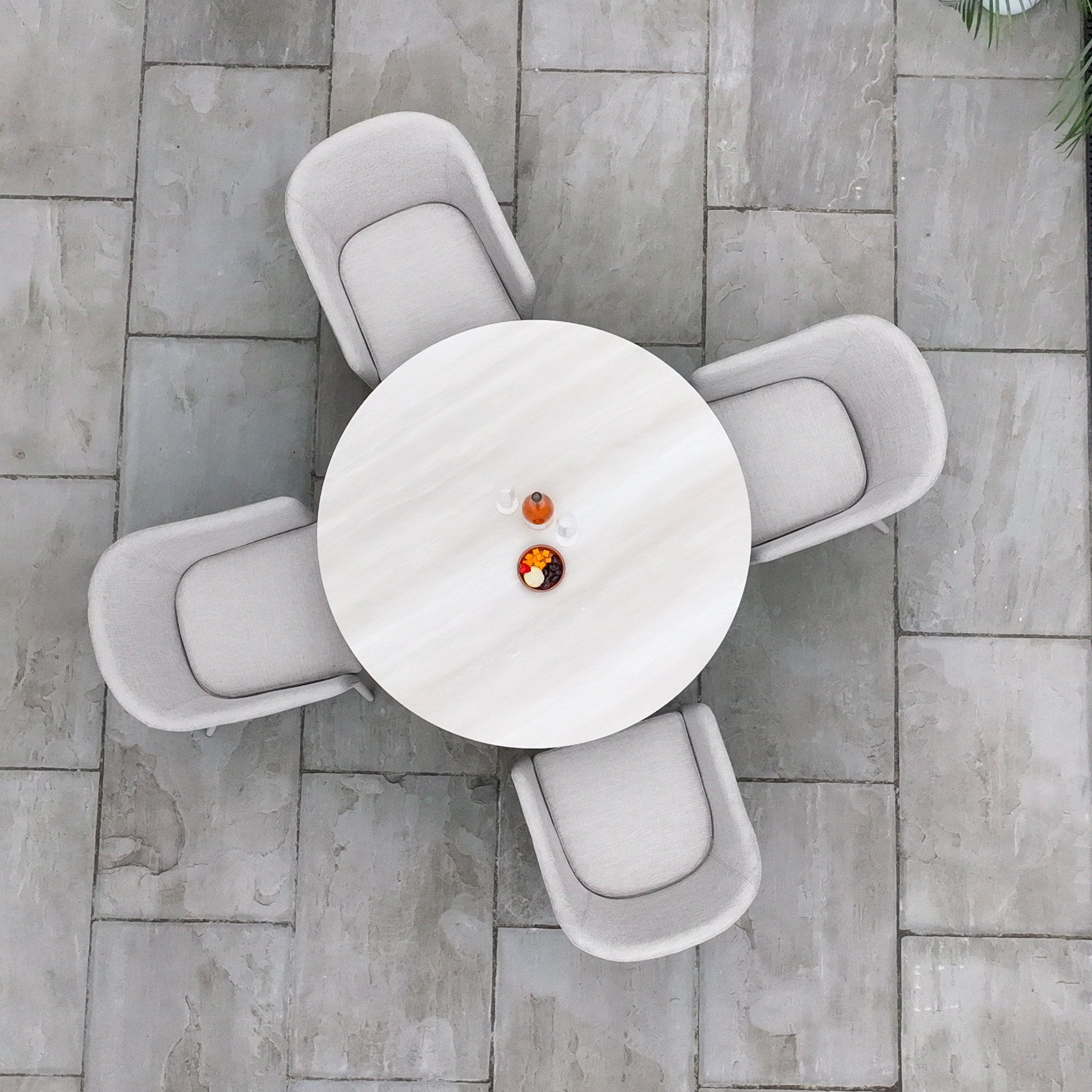 The Luna 4 Seat Round Outdoor Fabric Dining Set with Albatross Table in Fawn features a round ceramic table and four beige chairs, perfect for stylish patio dining.