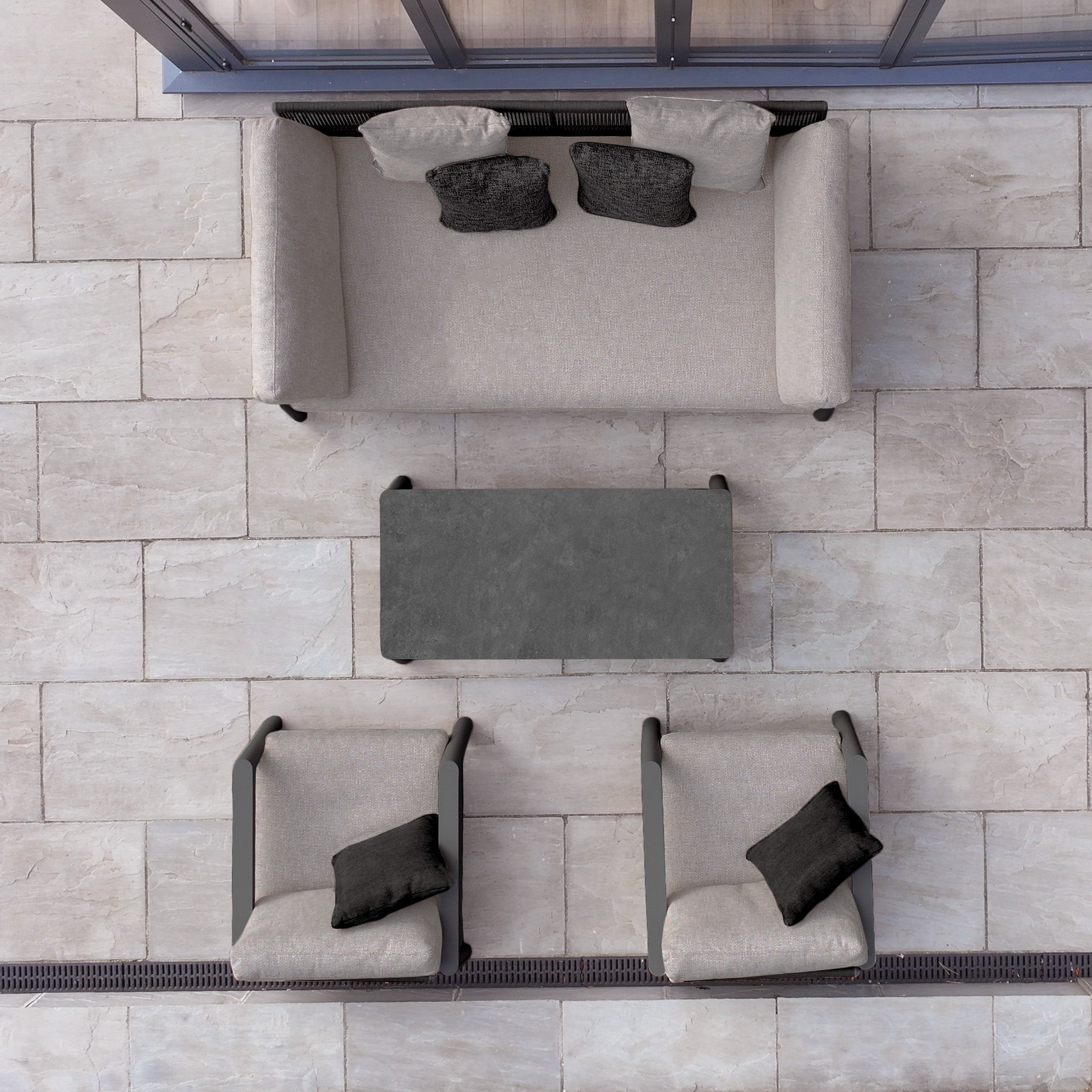 The Theia 3 Seat Sofa Set in Truffle includes a modular sofa, two chairs, a table, and cushions, all arranged on tiled flooring.
