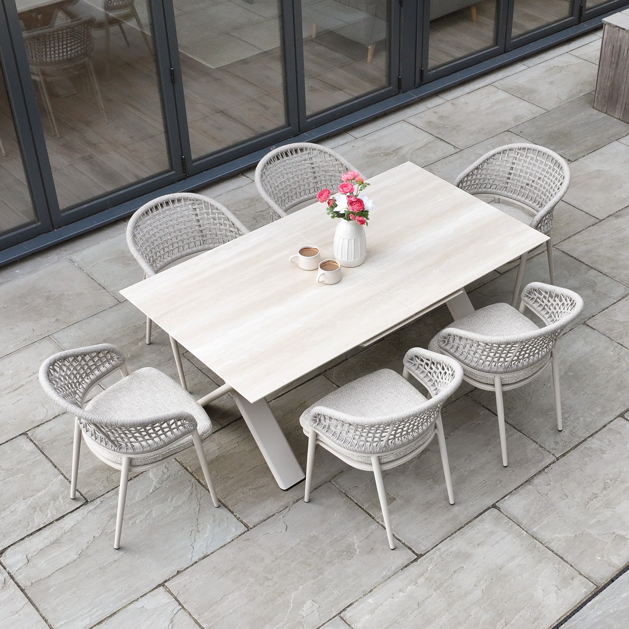 The Kalama 6 Seat Rope Dining Set with Albatross Extending Table in Oatmeal includes six rope chairs and a spacious, extendable table—perfect for stylish outdoor dining.