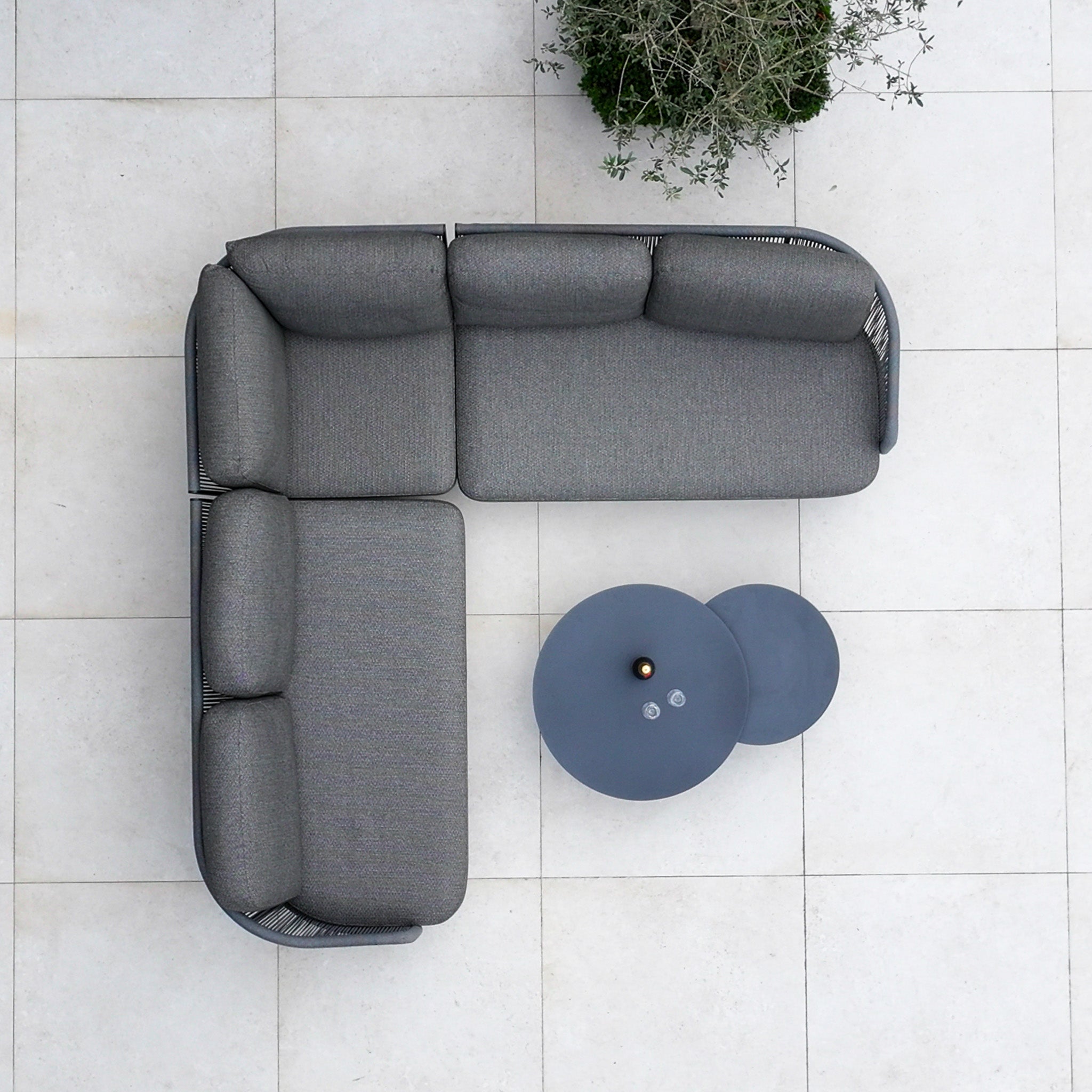 Top view of the Dekota Corner Sofa Set in Charcoal, with hydrophobic rope weave and two round tables on a tiled floor, plus a plant in the corner.