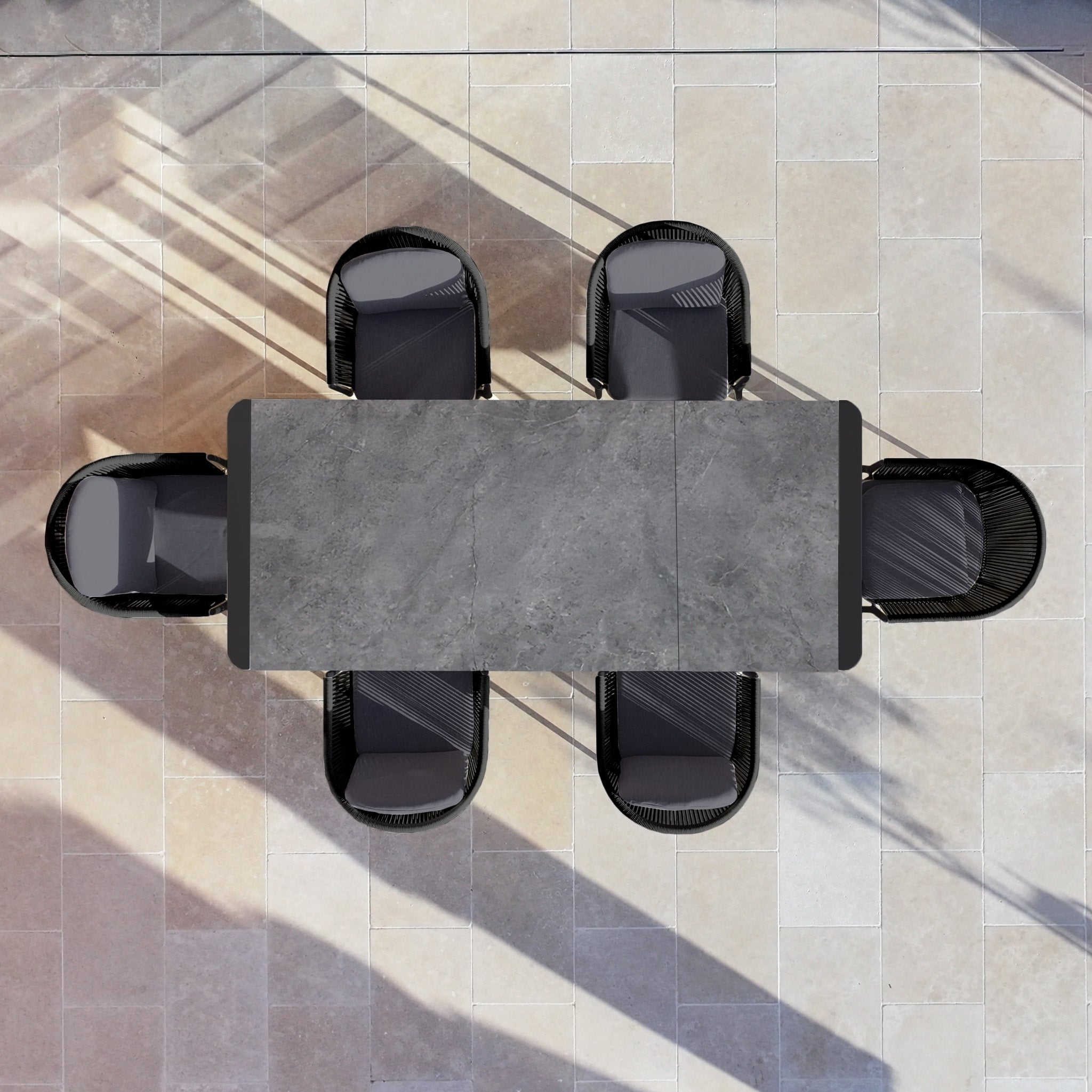 The Ravona 6 Seat Rope Extending Dining Set (162-222cm) in Charcoal is displayed with six black chairs on a tiled floor, viewed from above.