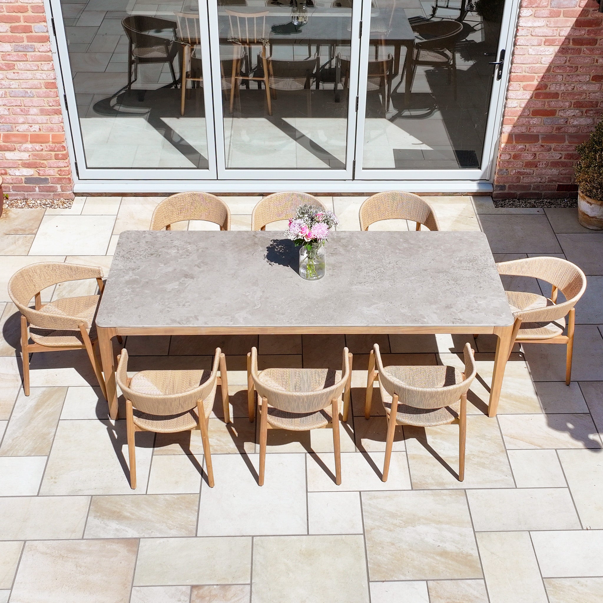 The Lucca 8 Seat Dining Set with Ceramic Top Table in Natural Weave features a rectangular ceramic table and eight chairs, making it a stylish outdoor furniture set ideal for gatherings.
