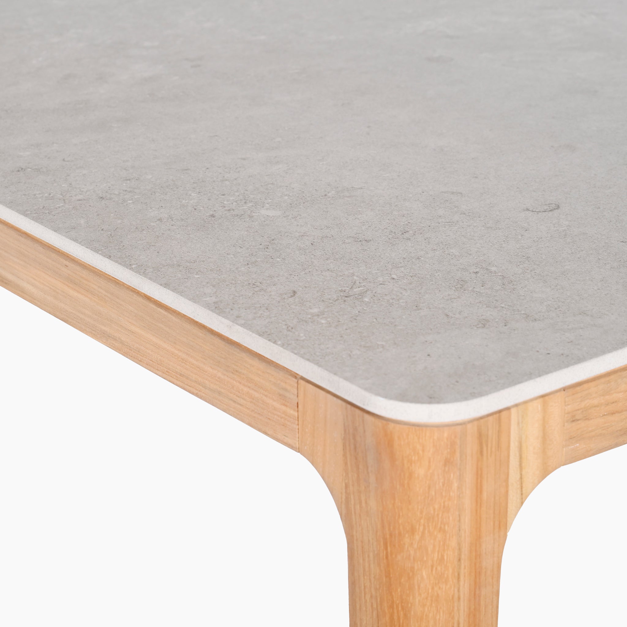 Close-up of a table corner with a smooth ceramic top and light wooden legs, echoing the elegance of the Sora 8 Seat Rope Dining Set with Ceramic Top Table in Stone.