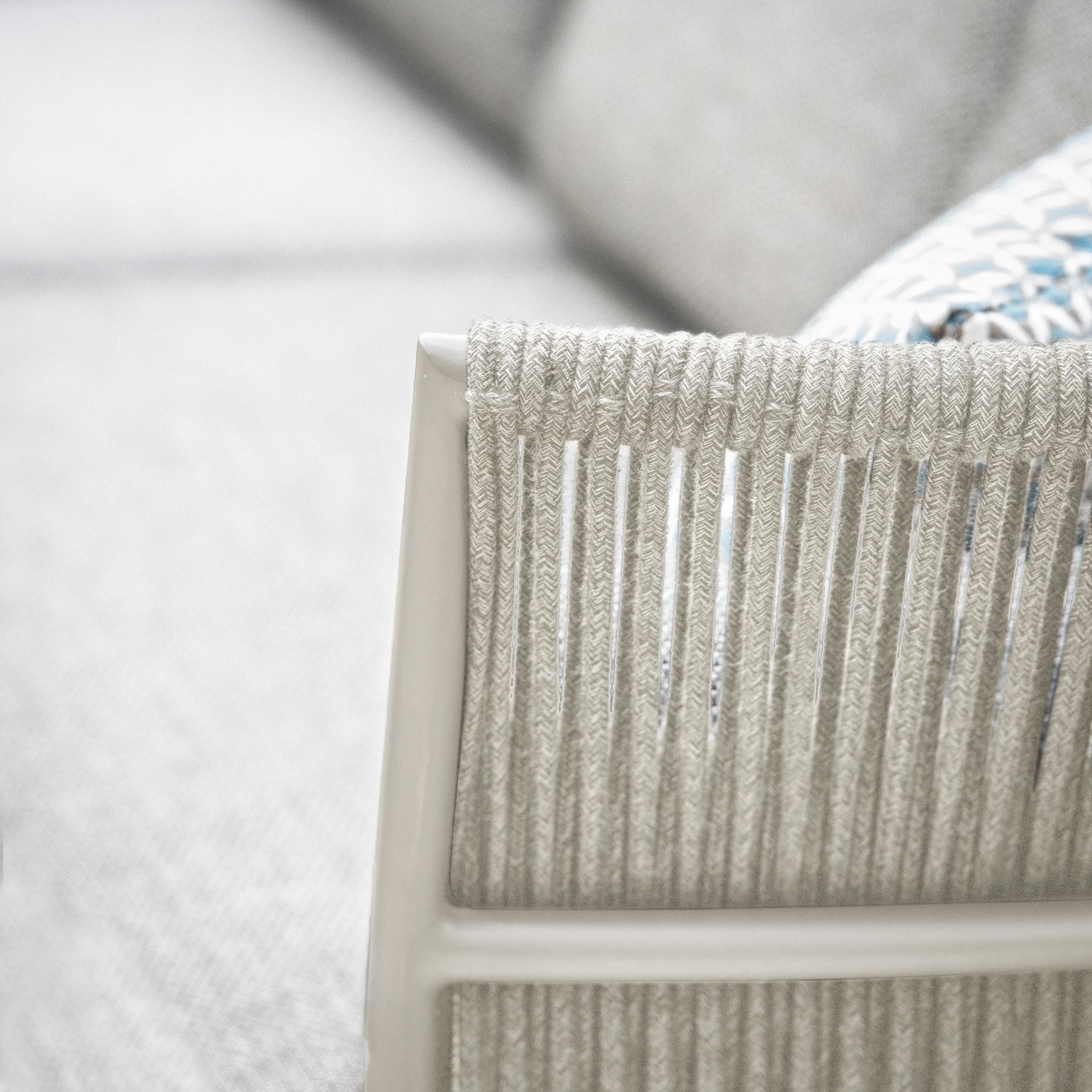 Close-up of a modern chair from the Salina Corner Group Set with Aluminium Table in Latte, featuring textured gray rope detailing on the backrest. This outdoor furniture set is weather-resistant and perfect for any stylish patio, all set against a soft, blurred background.