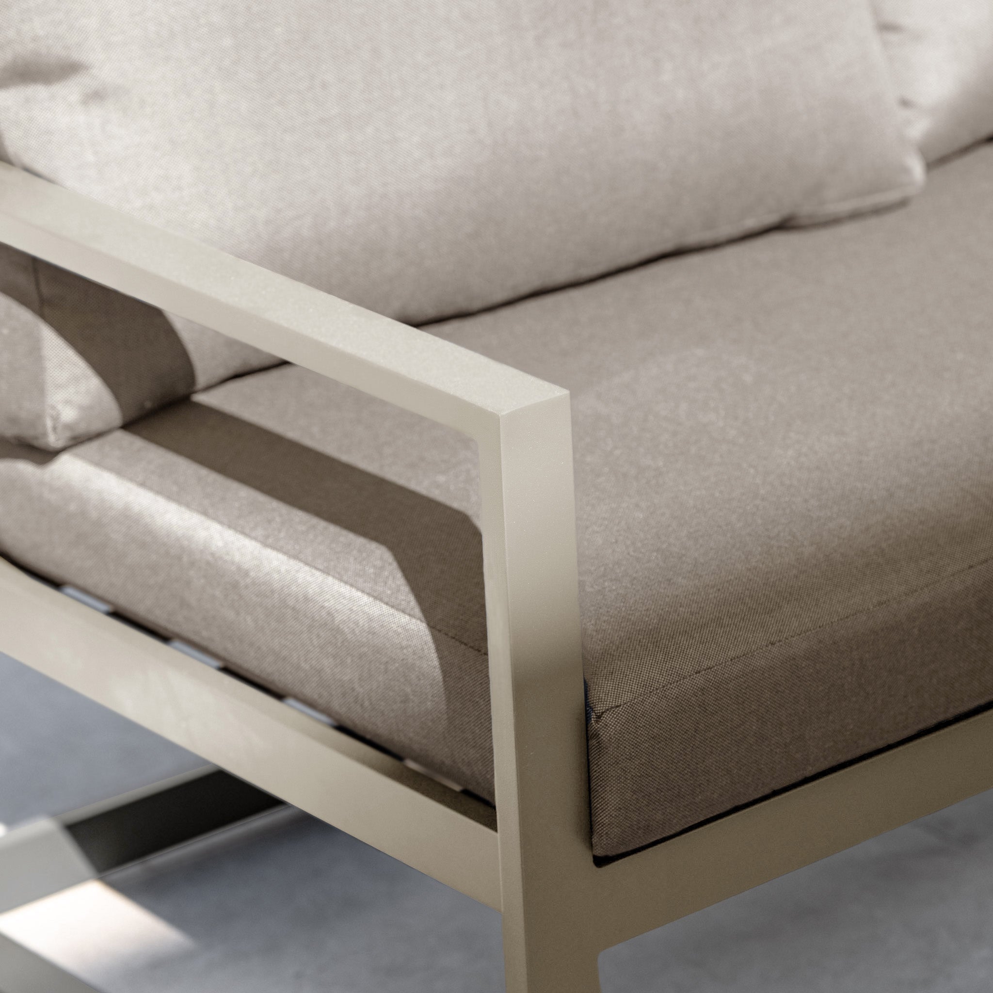 Close-up of the Havana Corner Group Set with reclining feature and coffee table in Latte, featuring beige cushions and metal frame, perfect for relaxed outdoor gatherings in natural light.