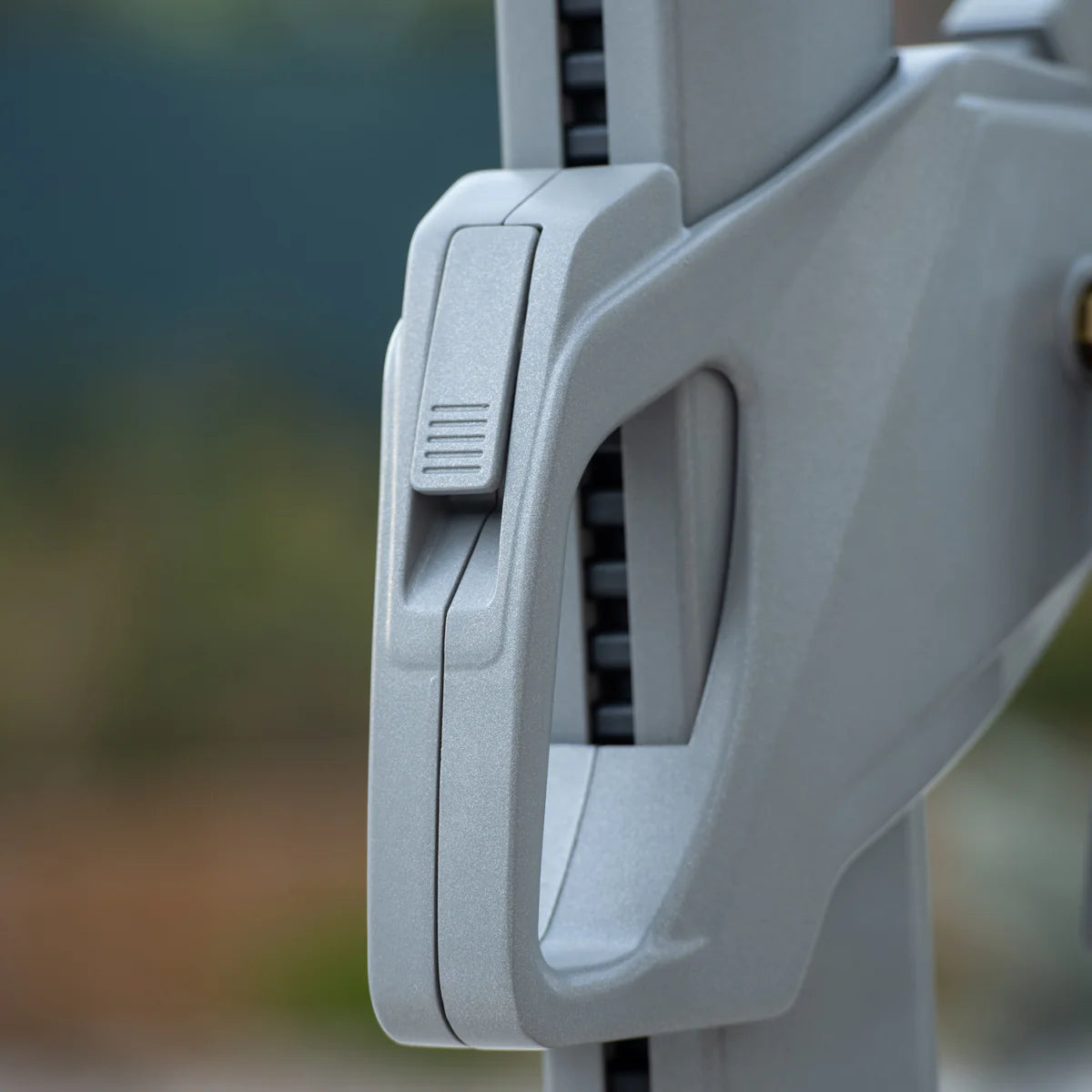 Close-up of the adjustable clamp mechanism, expertly designed for the Ares 3m Square Cantilever Parasol with Solar powered LED Lights in Charcoal, featuring a UV50+ canopy, against a blurred background.