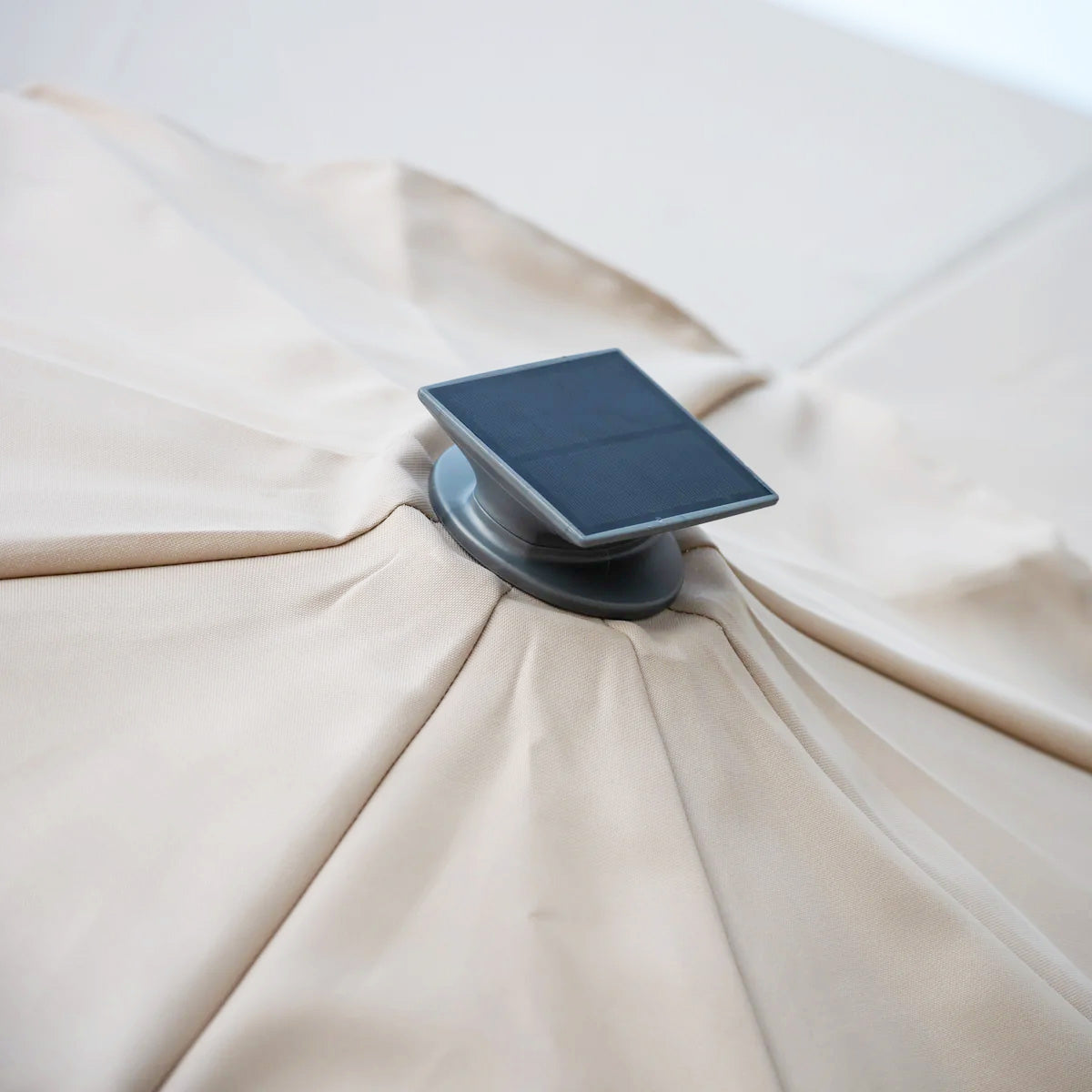 Close-up of the Ares 3.5m Round Cantilever Parasol in Beige, featuring solar-powered LED lights for evening ambiance, mounted on a pole.