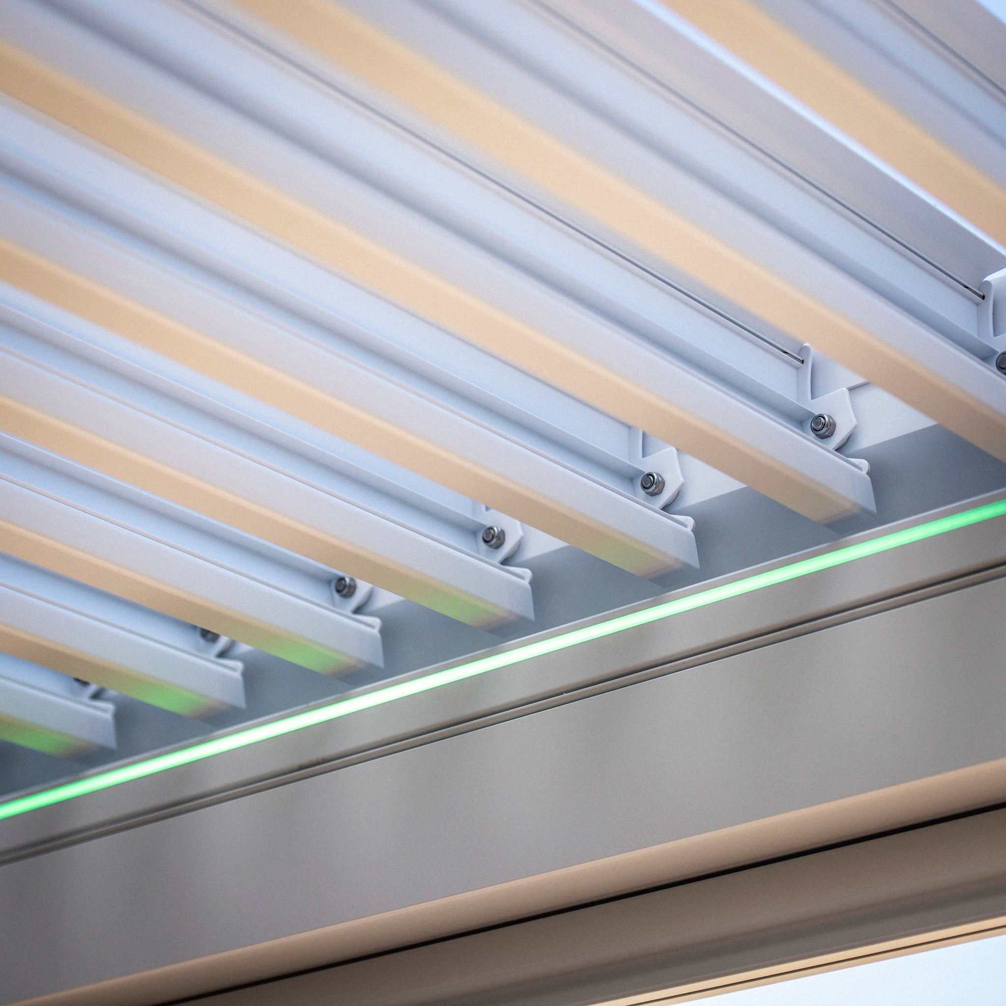 Close-up of PergoSTET Plus 3m x 4m Rectangular Pergola in white, showcasing horizontal slats with a built-in drainage system and subtle LED lighting underneath.