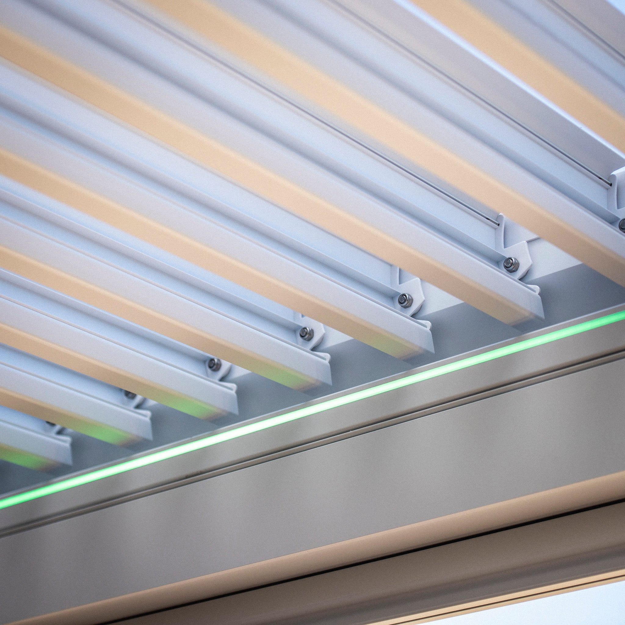 Close-up of white PergoSTET Plus panels with a green LED light strip underneath, seamlessly integrated into the sleek design of modern pergolas.