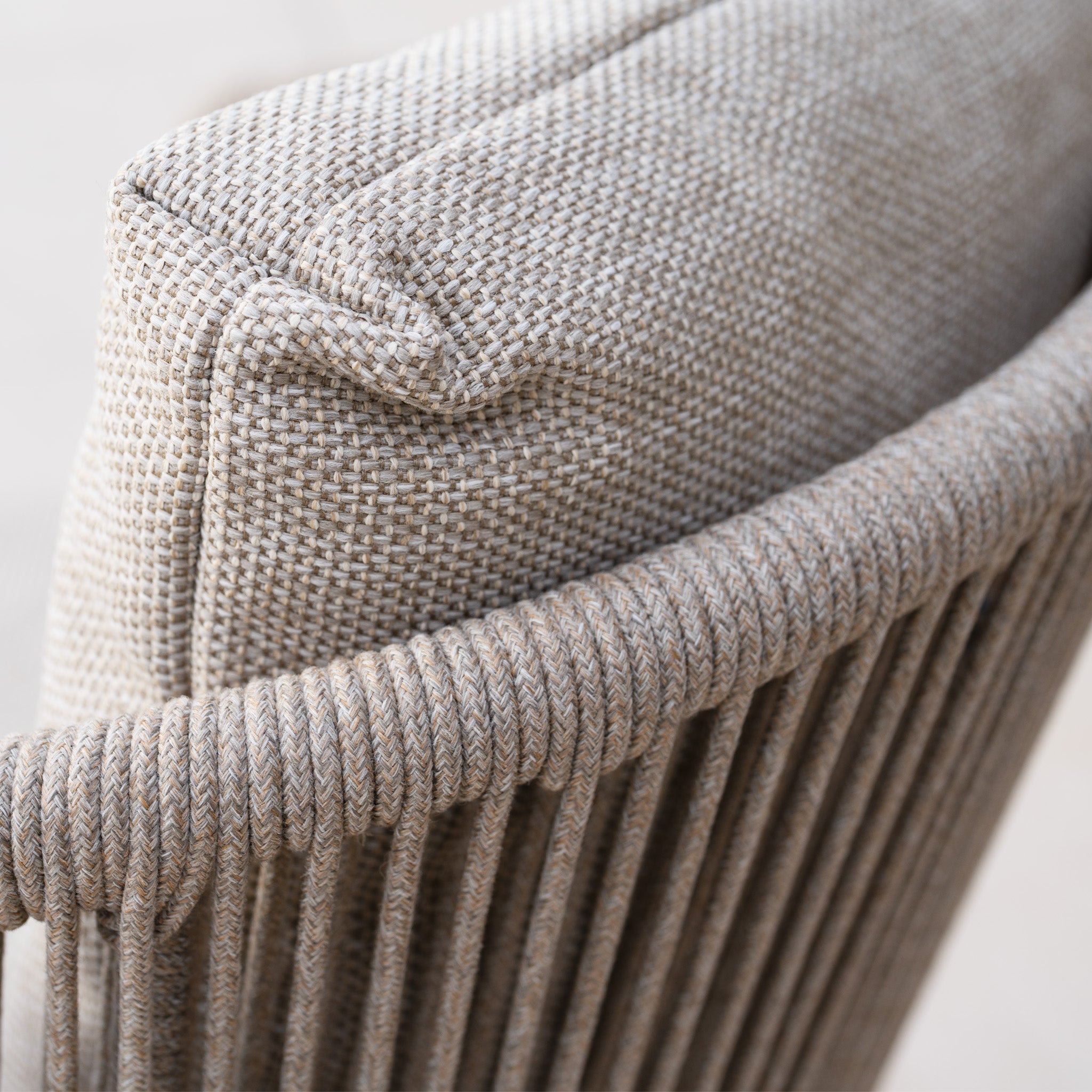 Close-up of the Dekota Dining Chair in Fawn showcasing its beige woven fabric cushion against the textured rope design of the backrest.