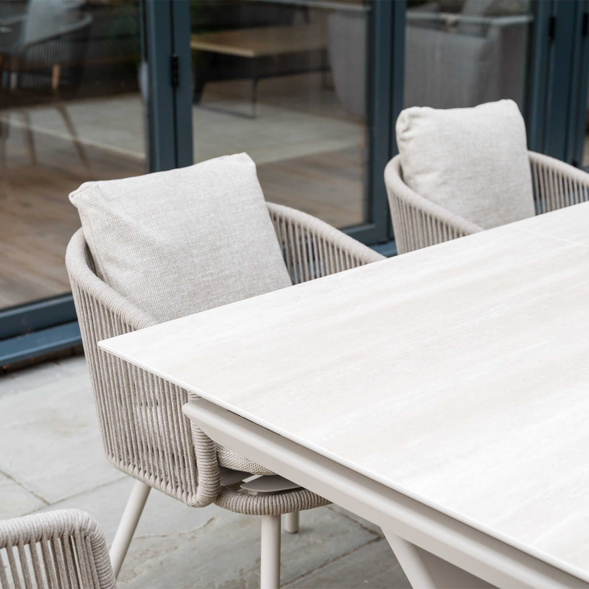 Six beige cushioned chairs and an Albatross Extending Table create the Dekota 6 Seat Rope Dining Set in Fawn, a stylish choice for outdoor dining on your patio.