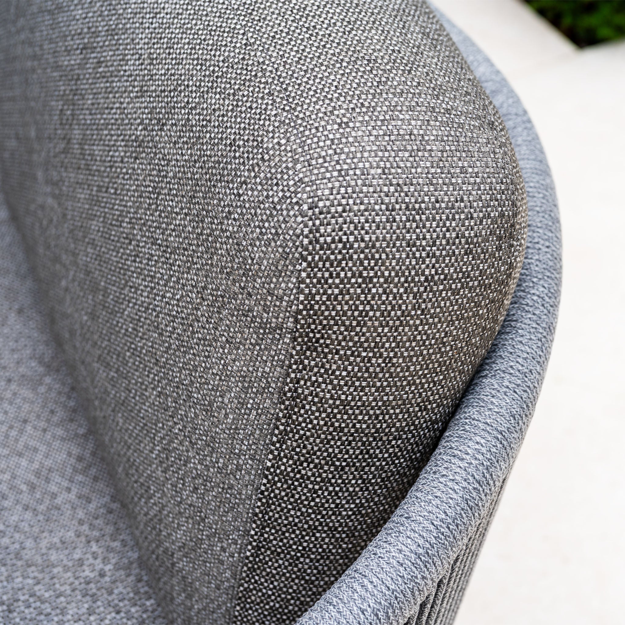 Close-up of a modern gray textured armchair with a curved design, perfectly paired with the Dekota Large Corner Sofa Dining Set with Altura Rising Table in Charcoal for stylish contemporary living spaces.