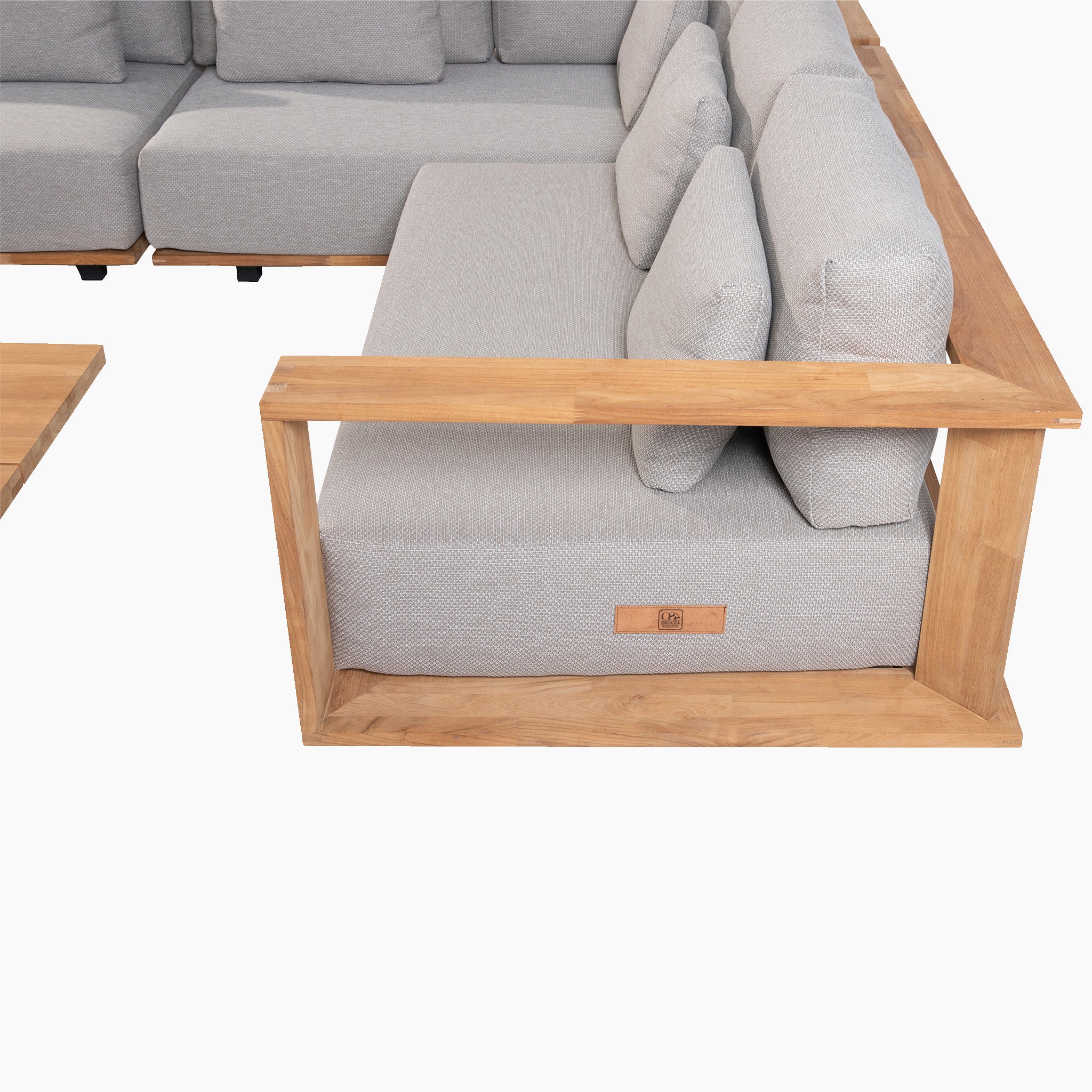 Light Grey Eternity Right Hand Teak Corner Group, featuring an L-shaped design with a sturdy wooden frame and extra thick lounge cushions, positioned at a corner angle. Complete the look with the matching side table on the left.