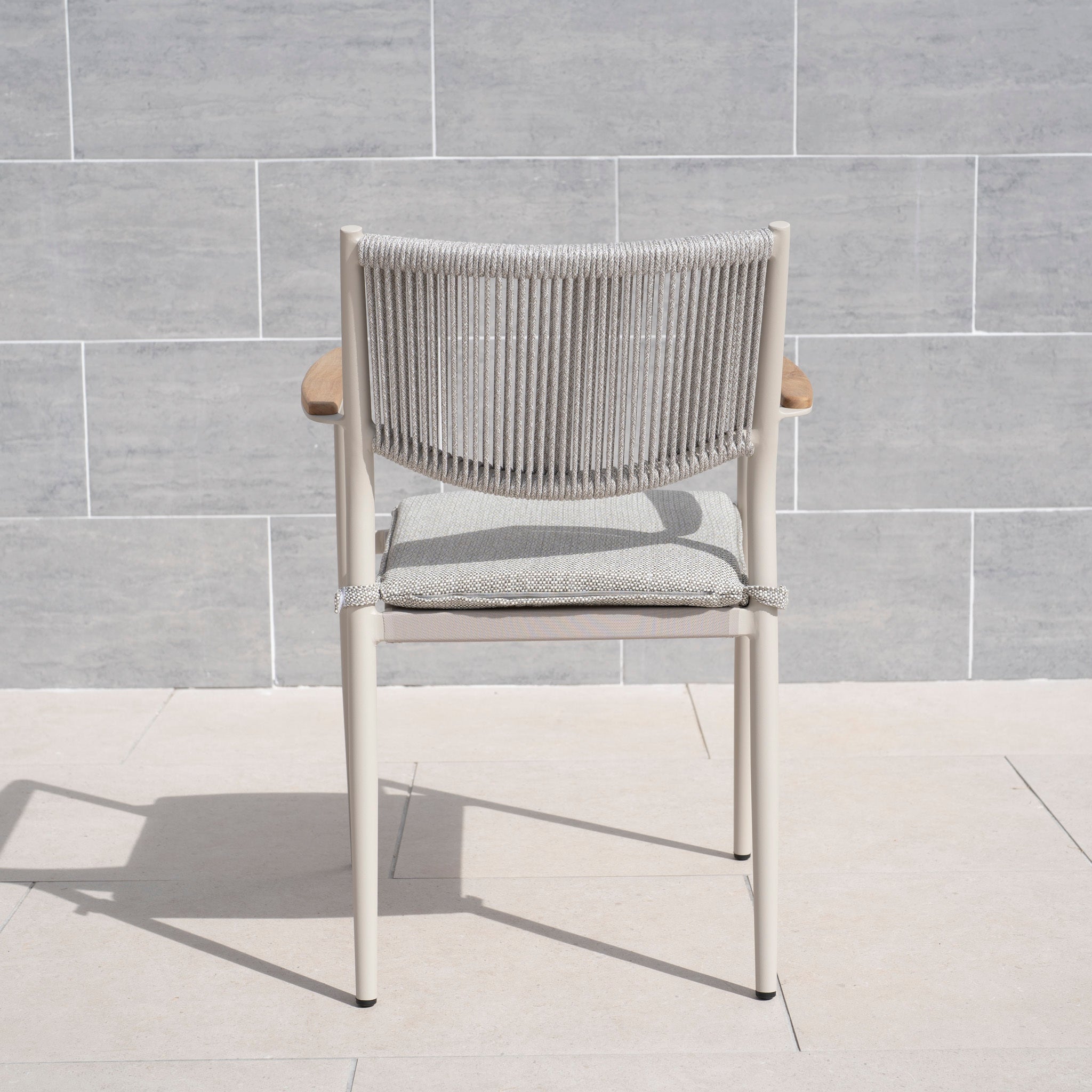 The Tellaro Rope Dining Chair in Latte (6pcs) showcases a hand-woven rope backrest and cushioned seat, ideal for modern outdoor dining areas with its stylish design—perfect for chic spaces.