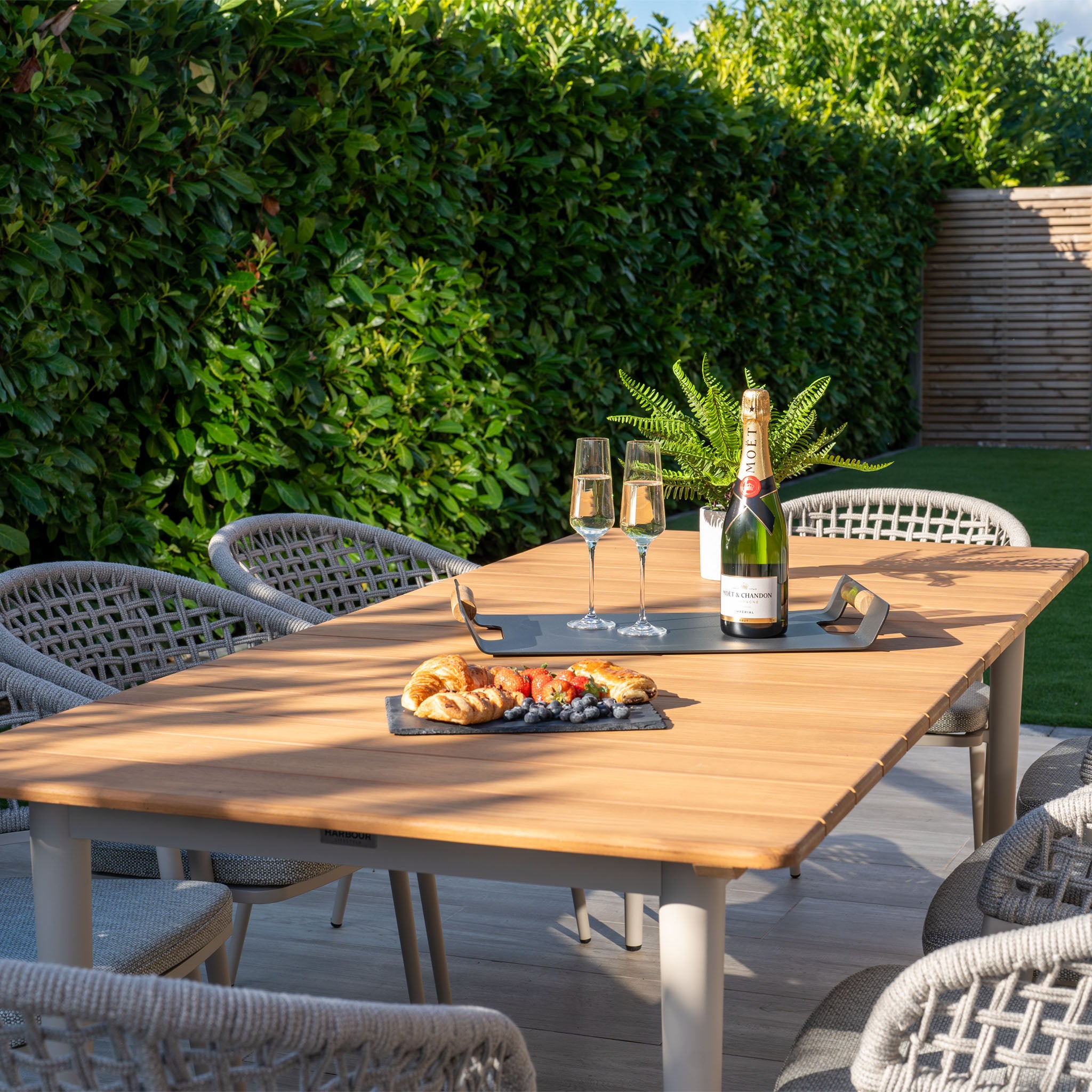 The Kalama 8 Seat Rectangular Dining Set with Teak Table in Latte showcases a breathtaking teak table perfect for displaying exquisite food and wine, providing both elegance and durability. Its weatherproof aluminum frame guarantees longevity for any gathering.
