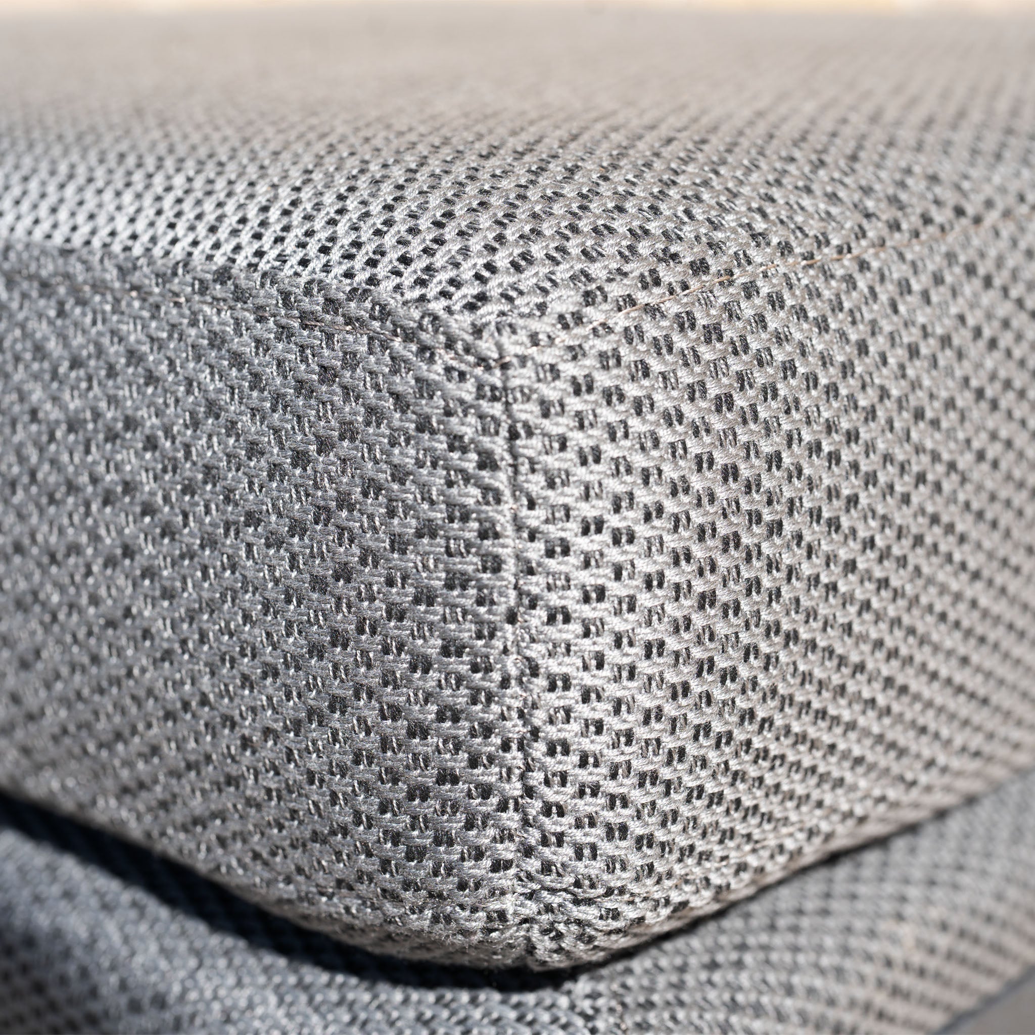 Close-up of the gray textured fabric cushion with visible corner stitching on the Luna Stool in Grey, an elegant outdoor furniture piece offering both style and durability.