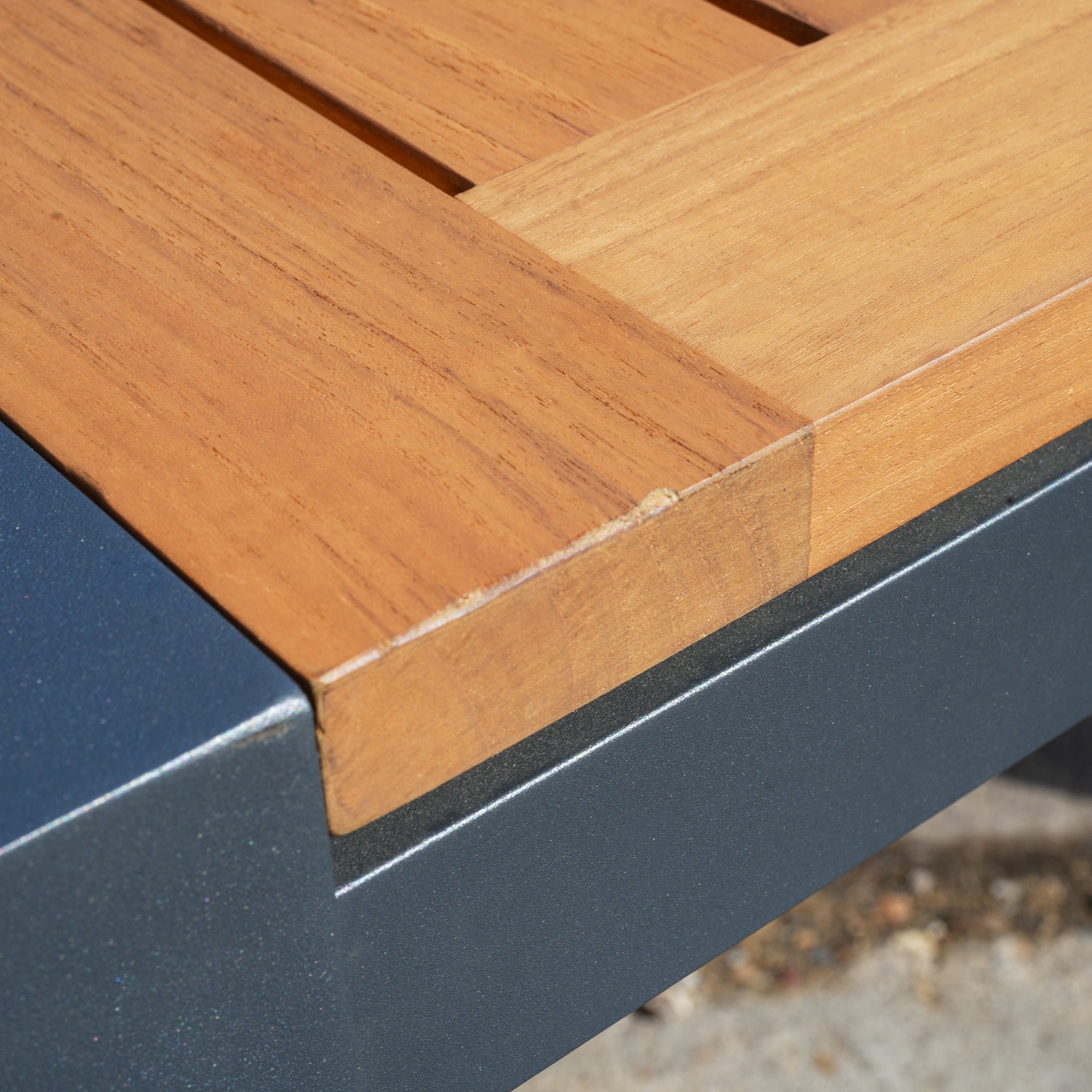 Close-up of the Pier Extending Dining Table with Teak Top (Ex Display), highlighting its teak surface and dark gray aluminium legs for a sleek, modern look.