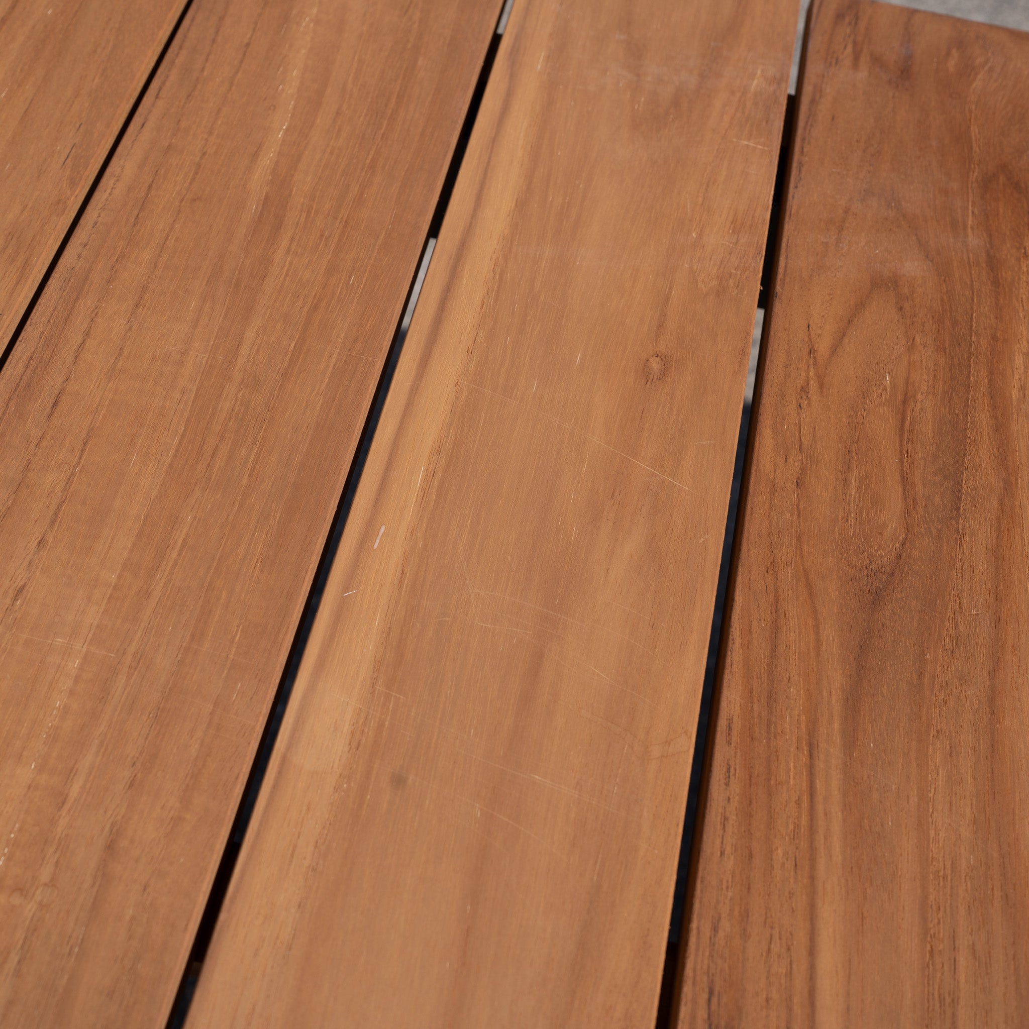 Close-up of the Bay 8 Seat Dining Table in Charcoal (Ex Display), featuring smooth, brown wooden planks with visible grain—perfect for your dining space. See our wooden care guide to preserve its lasting beauty.