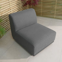 The Luna Outdoor Fabric Middle Extension Piece in Grey is an elegant patio lounge option with quick-dry foam cushions. It complements a tiled patio with wooden slat fencing and vibrant potted plants, ideal for outdoor fabric enthusiasts.