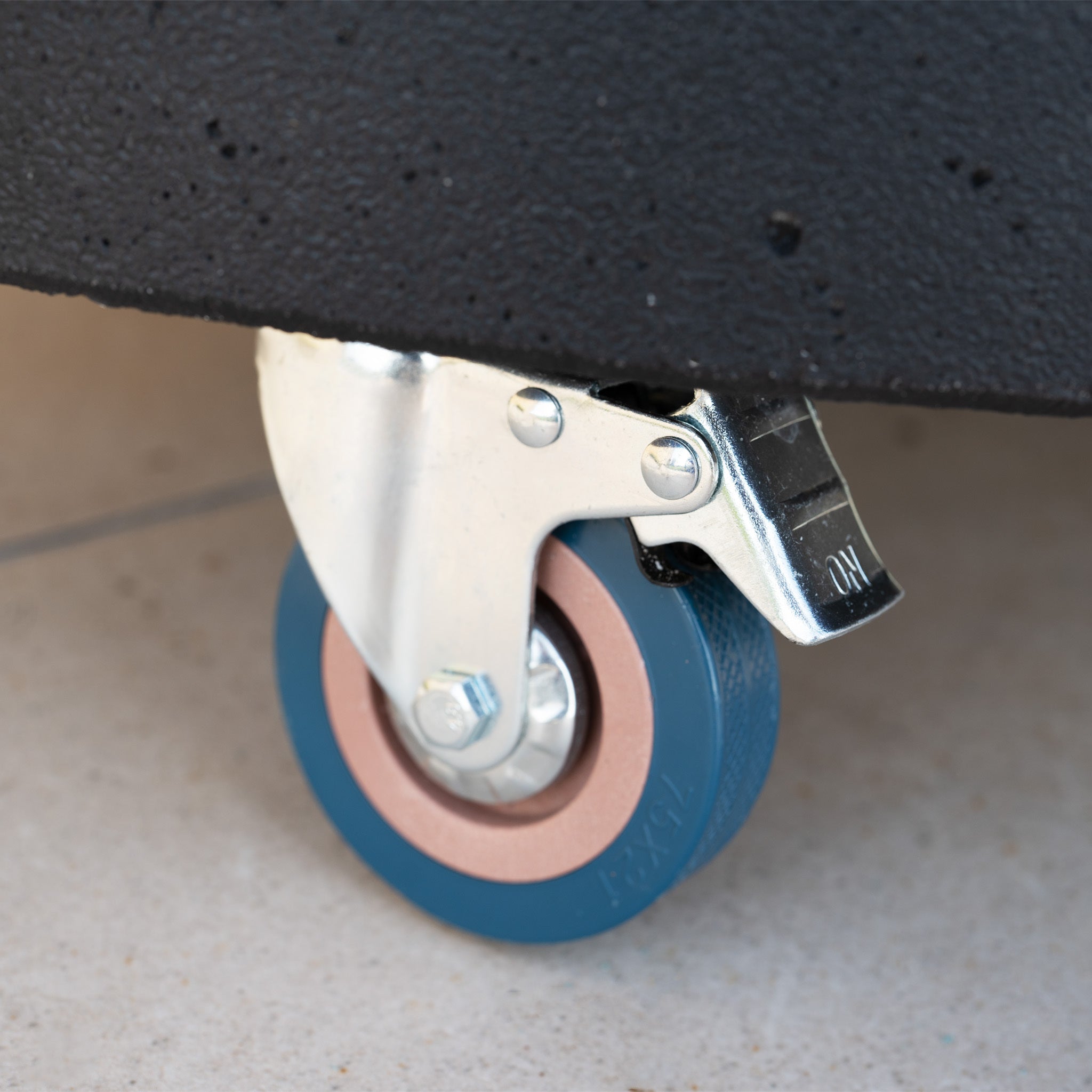 Close-up of the 50kg Concrete Parasol Base with Handles & Wheels, showing its blue caster wheel and metal brake attached underneath.