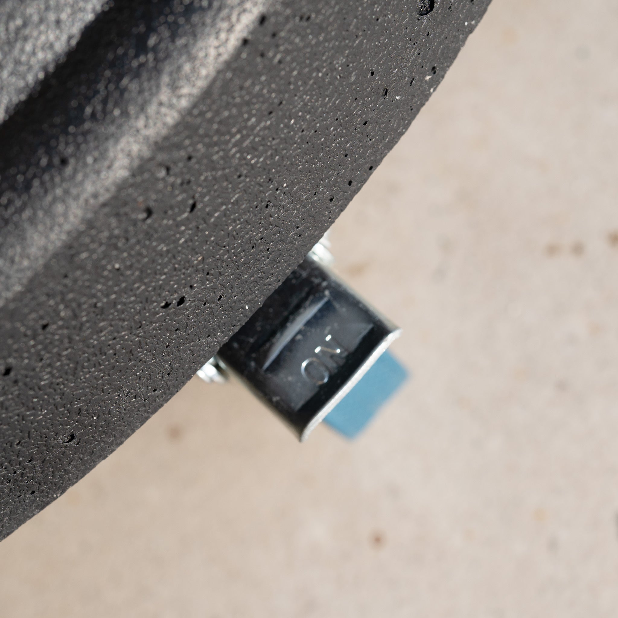 Close-up of a valve stem on a black tire with "N2" engraved on the metal cap, evoking the sleek finish of the 50kg Concrete Parasol Base with Handles & Wheels.