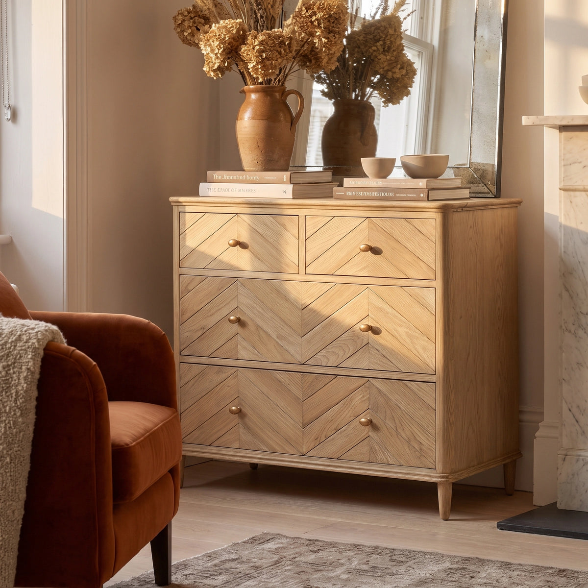 Hadley Herringbone 2 Over 2 Chest of Drawers in Natural decorated with books, vases, dried flowers, and a mirror in a cozy sunlit room.