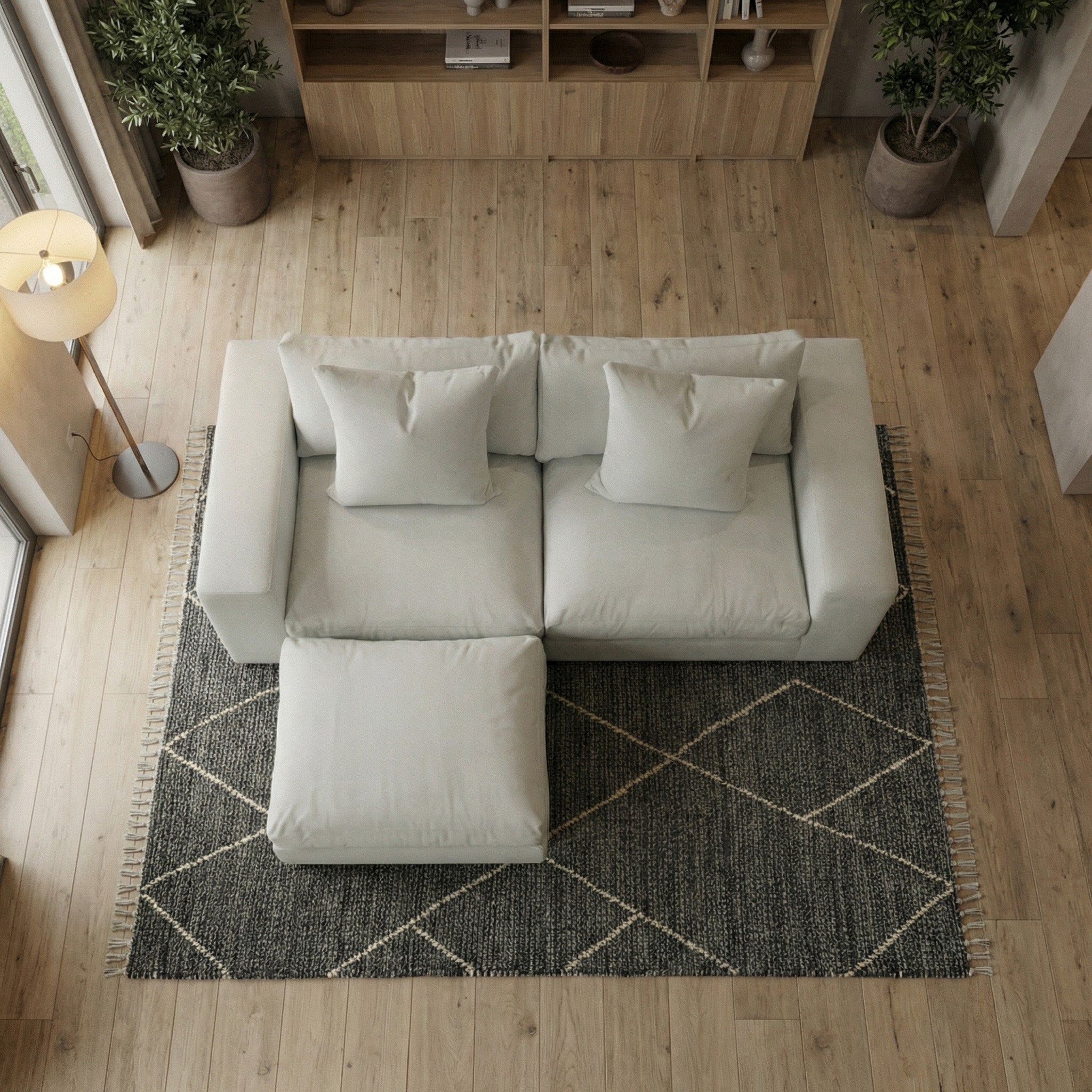 The Hampshire Modular 2 Seat Sofa in Classic Grey with duck feather cushions sits on a dark geometric rug in a cozy living room with wooden floors.