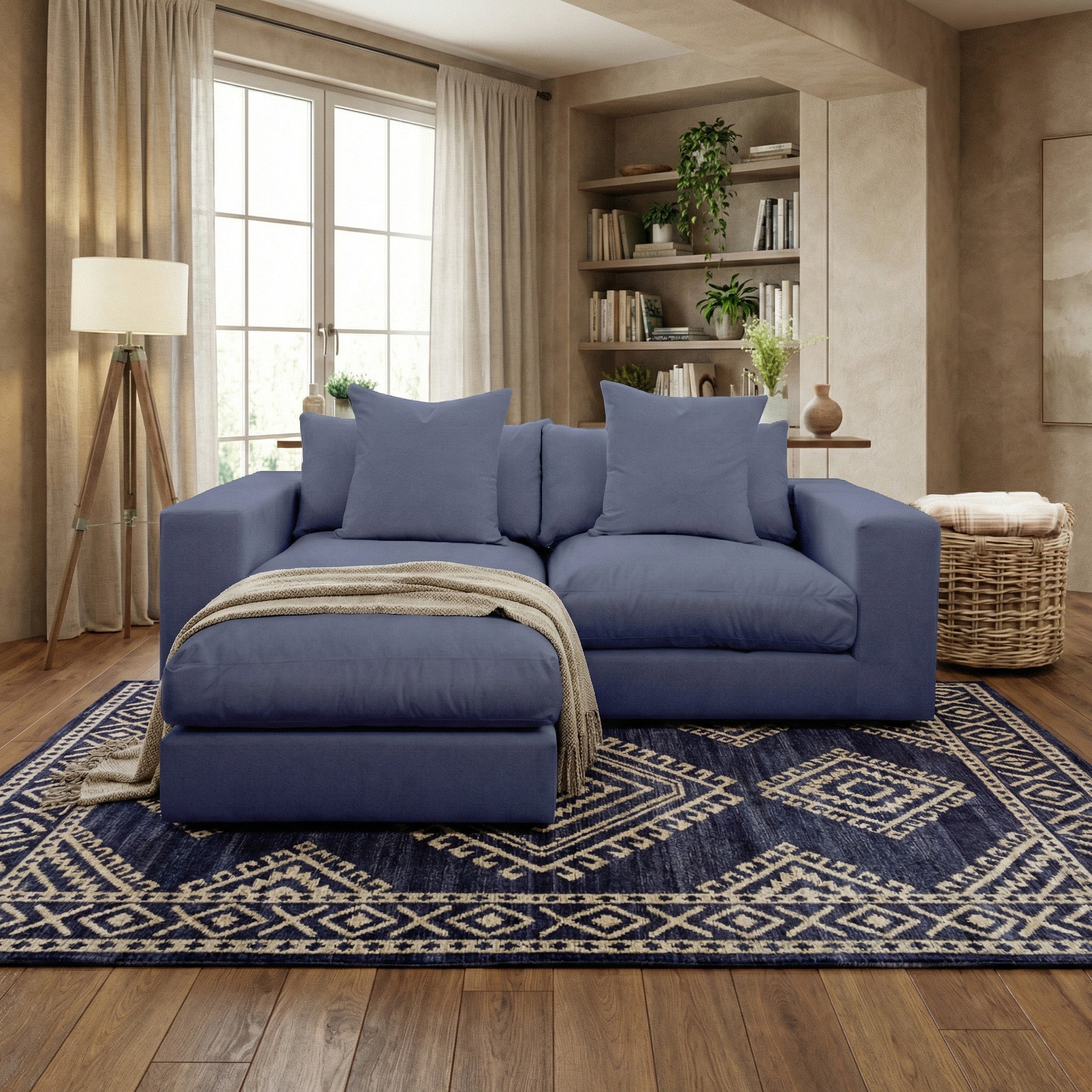 The Hampshire Modular 2 Seat Sofa in Midnight Blue, featuring duck feather cushions and pillows, sits on a patterned rug in a bright, cozy living room.