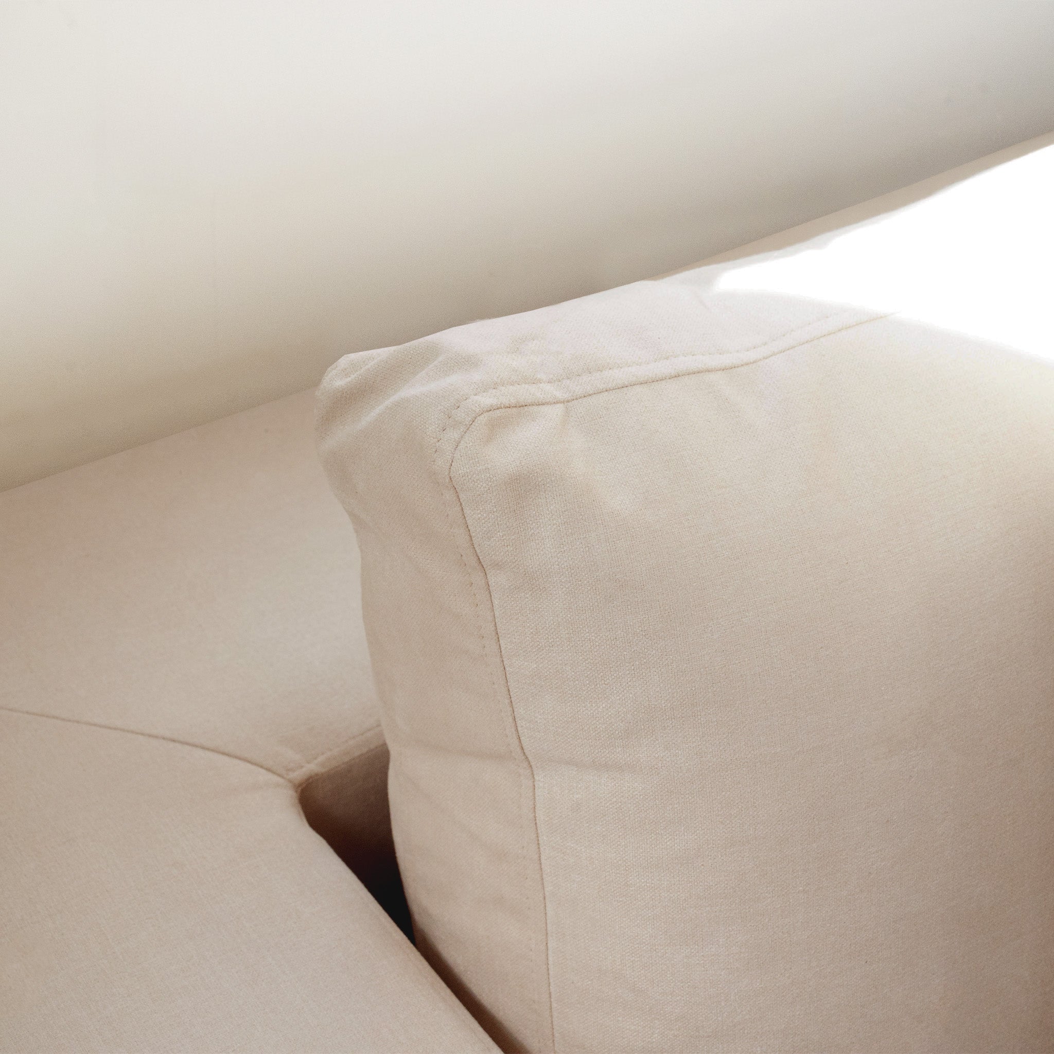 Close-up of the Hampshire Modular 4 Seat Sofa in Beige, with soft cushions in natural sunlight, crafted from sustainably sourced hardwood and featuring luxurious duck feather and down filling.