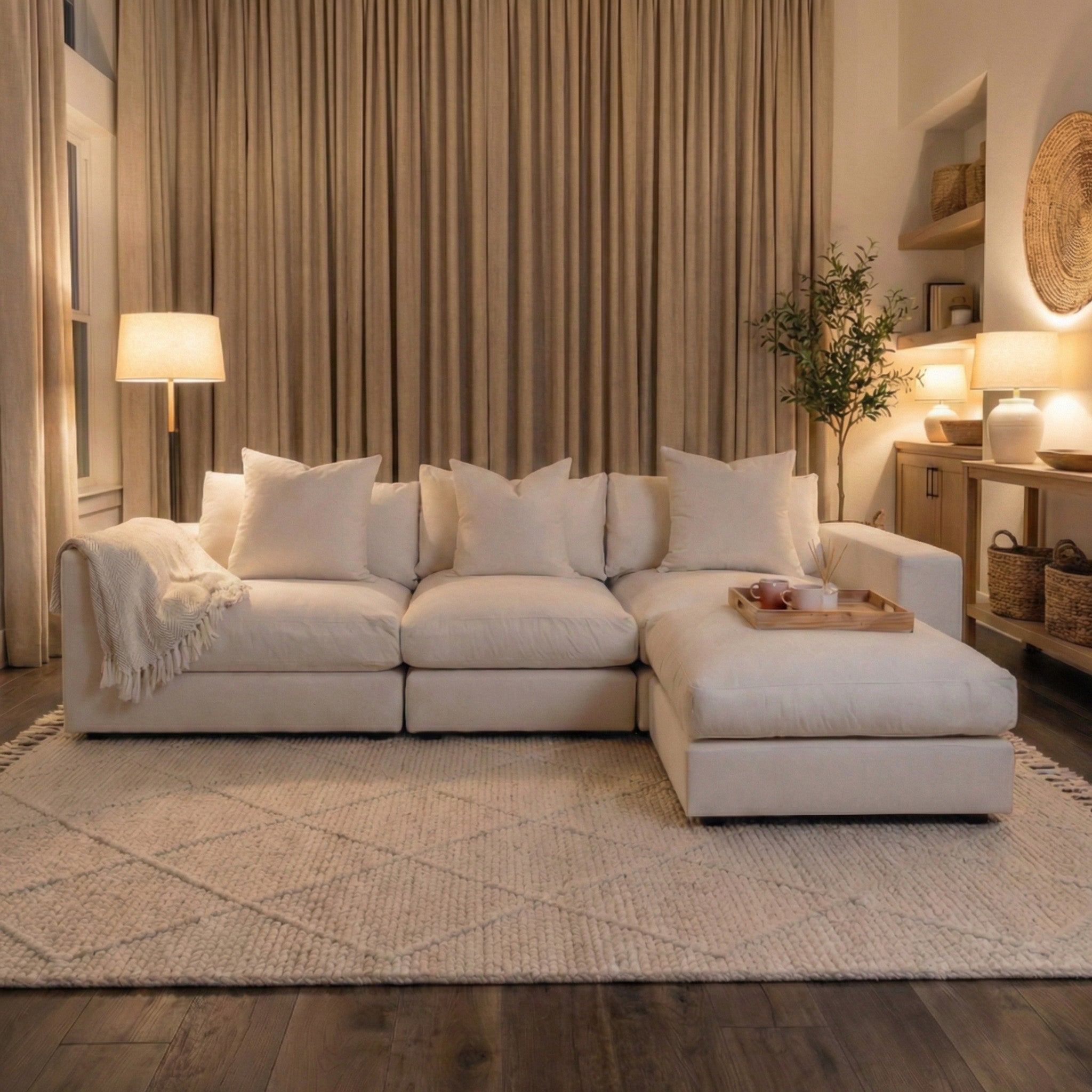 Cozy living room with the Hampshire Modular 3 Seat Sofa in Ivory, featuring duck feather cushions, a throw blanket, lamps, and neutral décor atop a patterned rug.