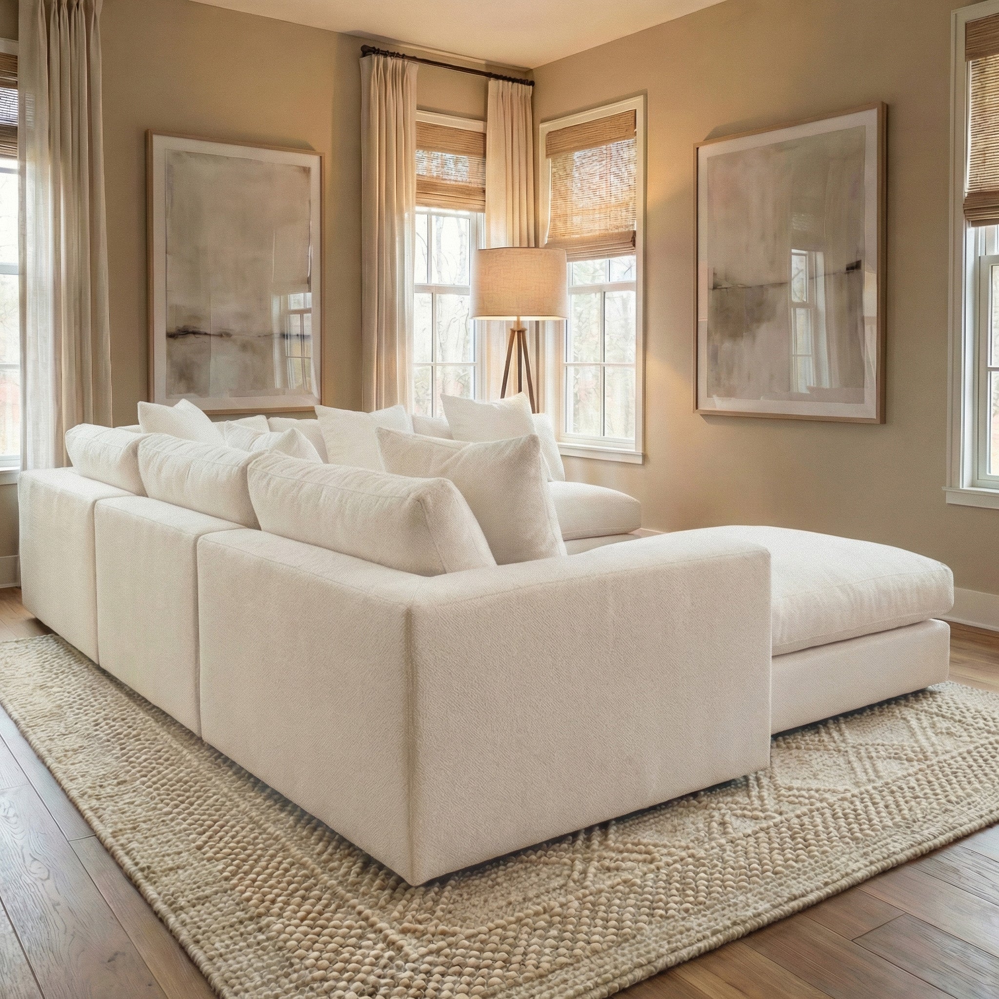 Modern living room with a spacious Hampshire Modular Corner Sofa in Ivory, neutral decor, and bold abstract wall art. Handmade in England, this stylish sofa combines comfort with modern elegance.