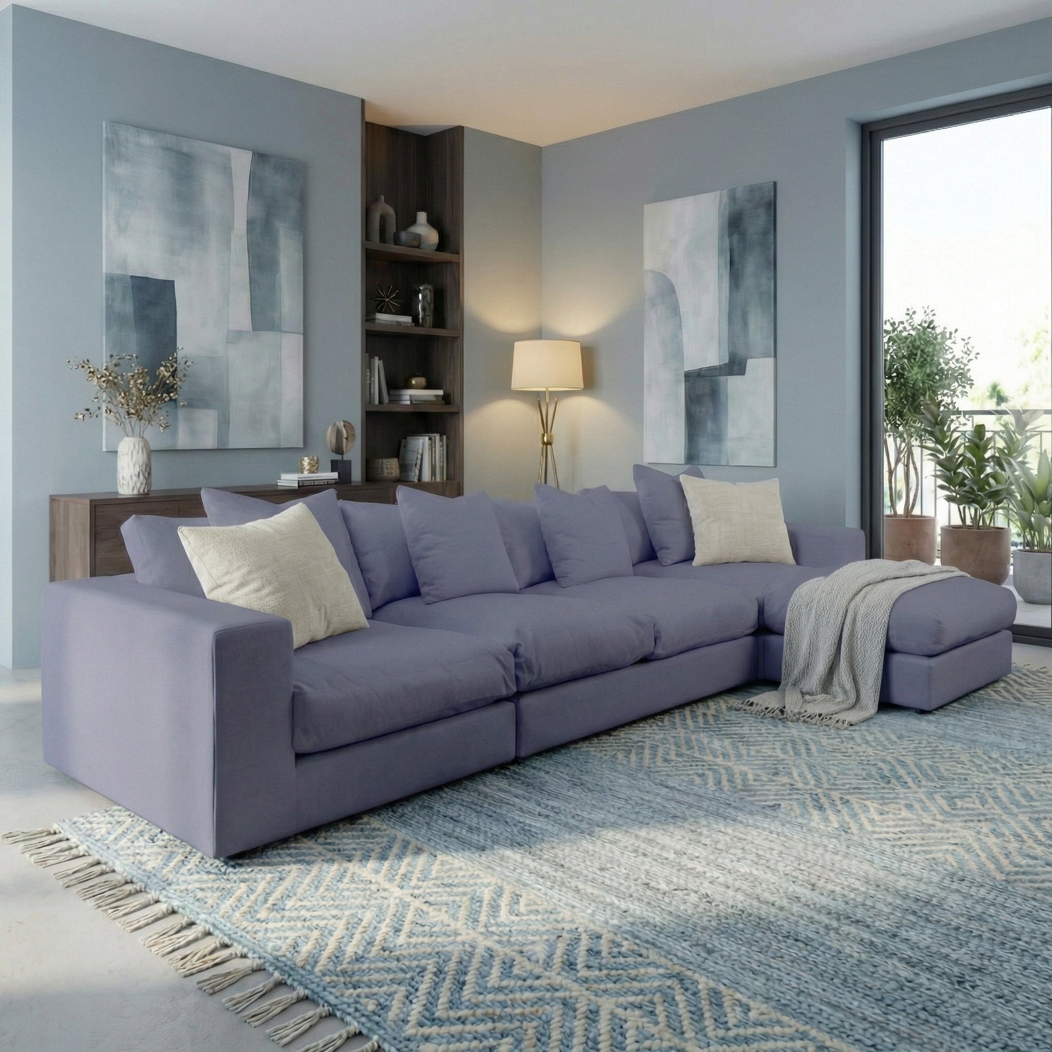 Modern living room with the Hampshire Modular 4 Seat Sofa in Midnight Blue featuring plush duck feather cushions, abstract art, and a window view of greenery.
