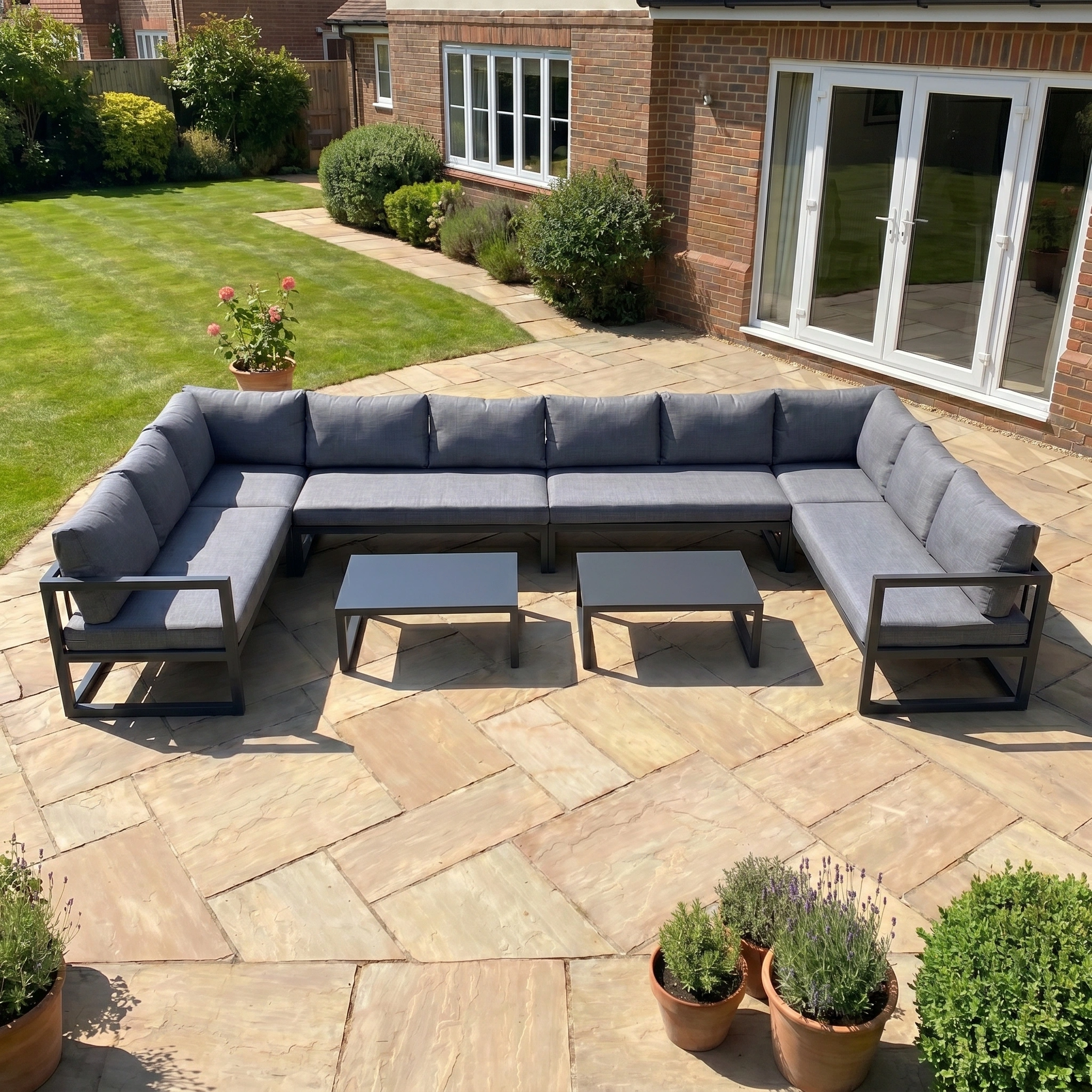 The Havana U-Shape Corner Group Set with Reclining Feature and Coffee Tables in Charcoal is ideal for stylish outdoor relaxation on a sunny patio, blending comfort and luxury in your garden space.