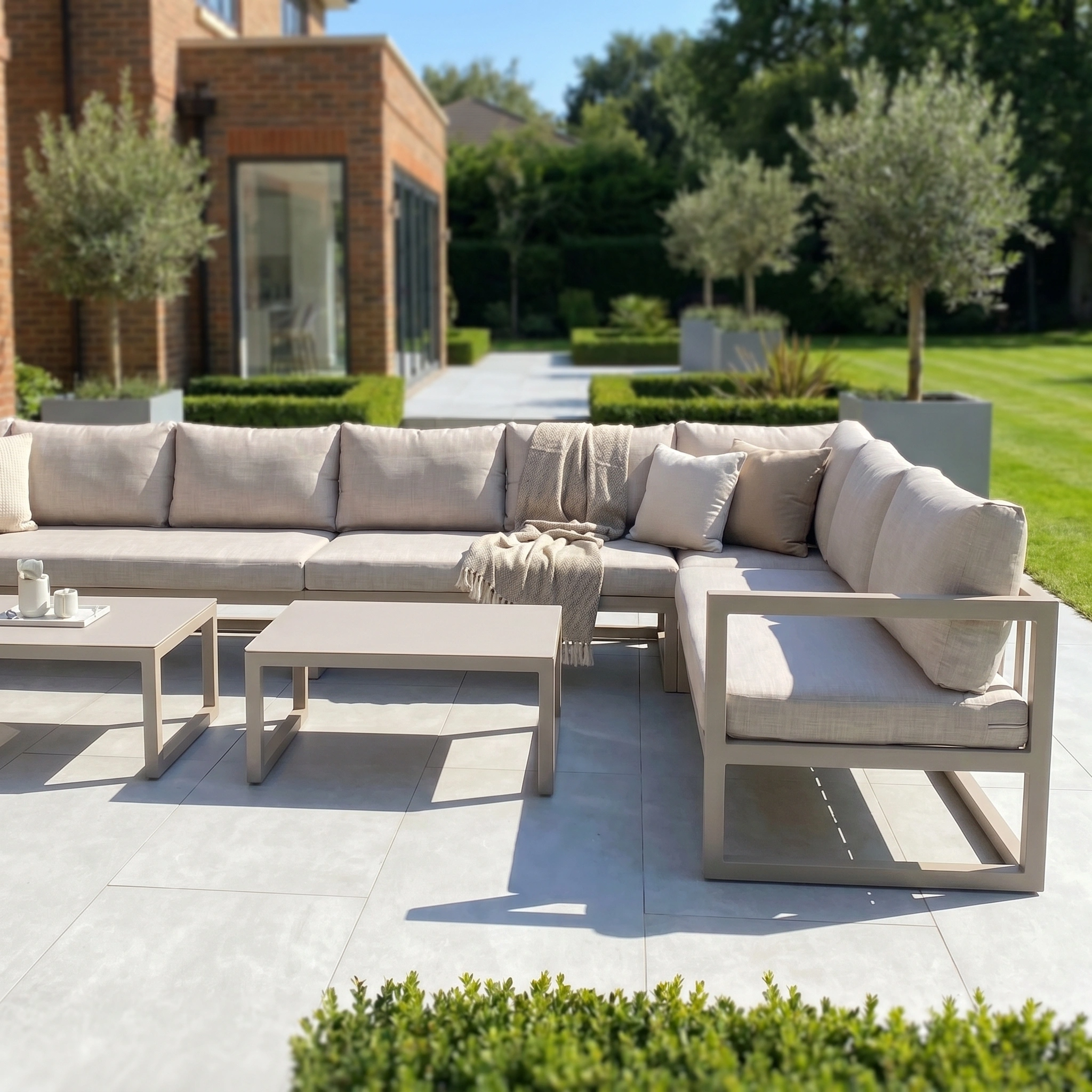 Outdoor patio featuring the Havana U-Shape Corner Group Set with reclining feature and coffee tables in Latte, set in a modern garden with greenery—perfect for relaxing on this stylish outdoor furniture.