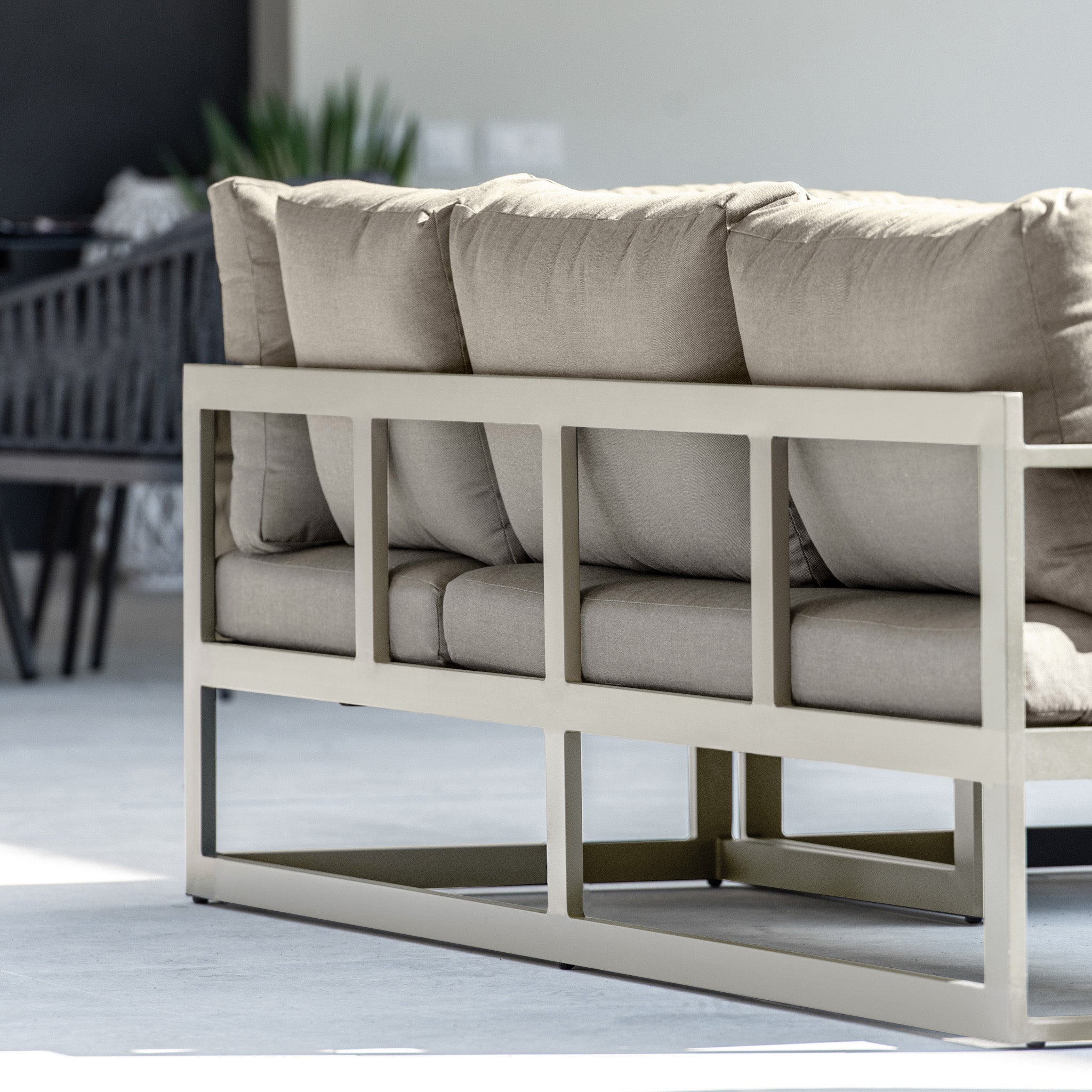 The Havana Corner Group Set with Reclining Feature and Coffee Table in Latte features a beige metal frame and light brown cushions, perfect for a modern, minimalistic indoor space.