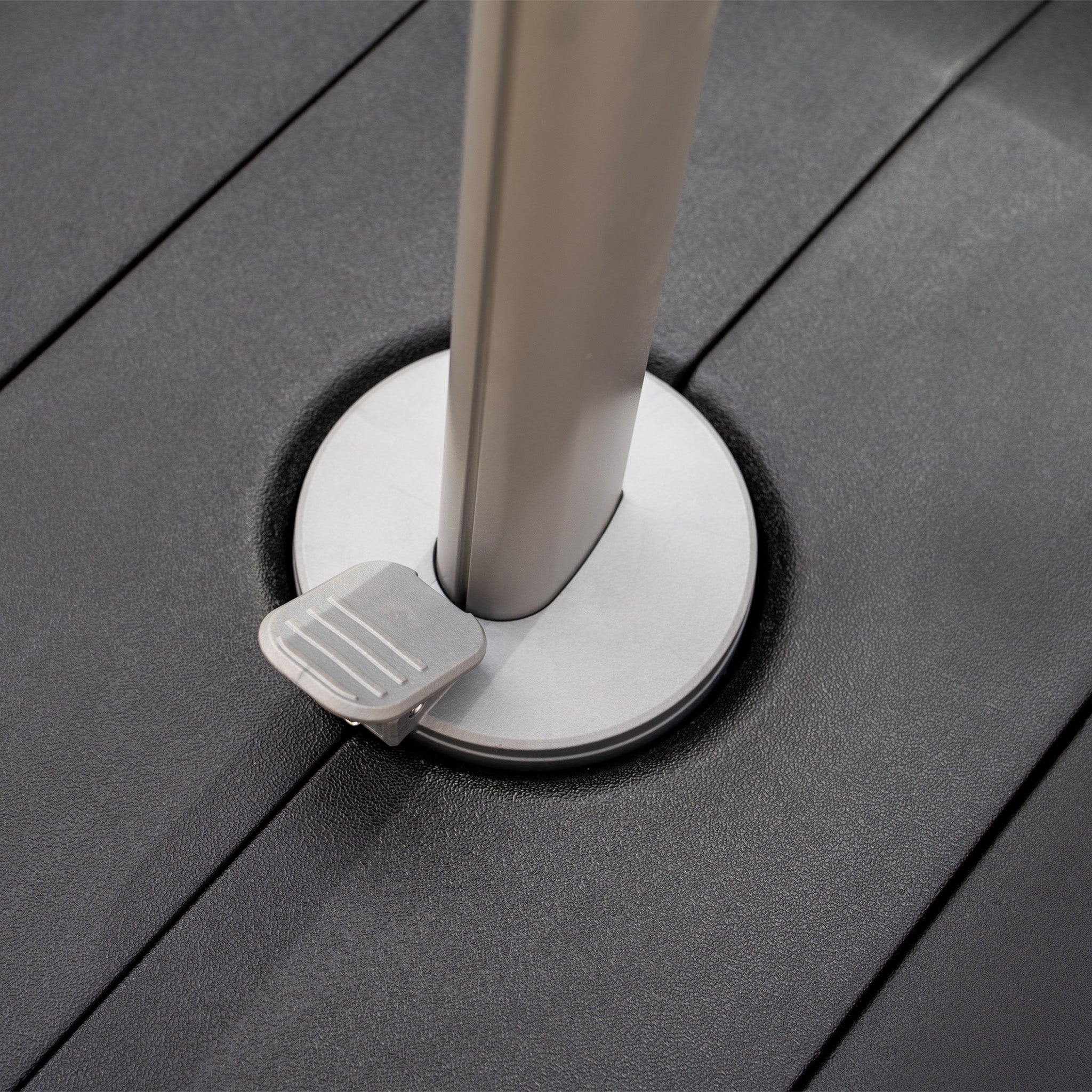 Close-up of the Hera 2.7m Square Cantilever Parasol in Beige featuring LED lighting, with a metallic pole and foot pedal visible on a dark textured surface.