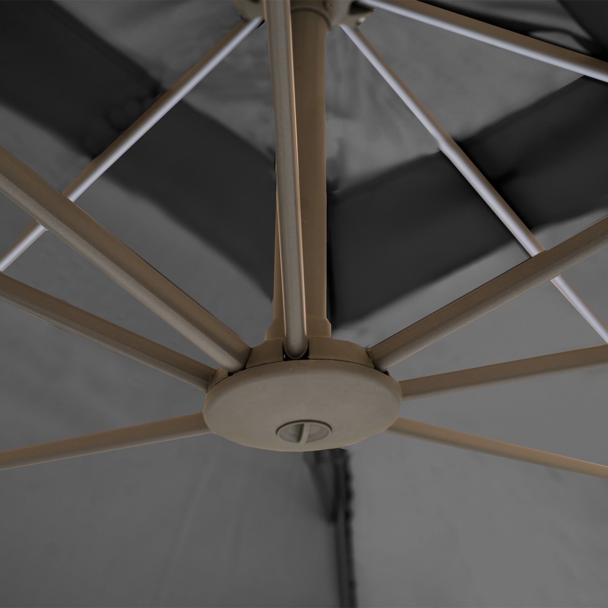 Close-up view from below of the Hera 3m x 2m Rectangular Cantilever Parasol's spokes and central hub, featuring a charcoal canopy offering UV50+ protection.