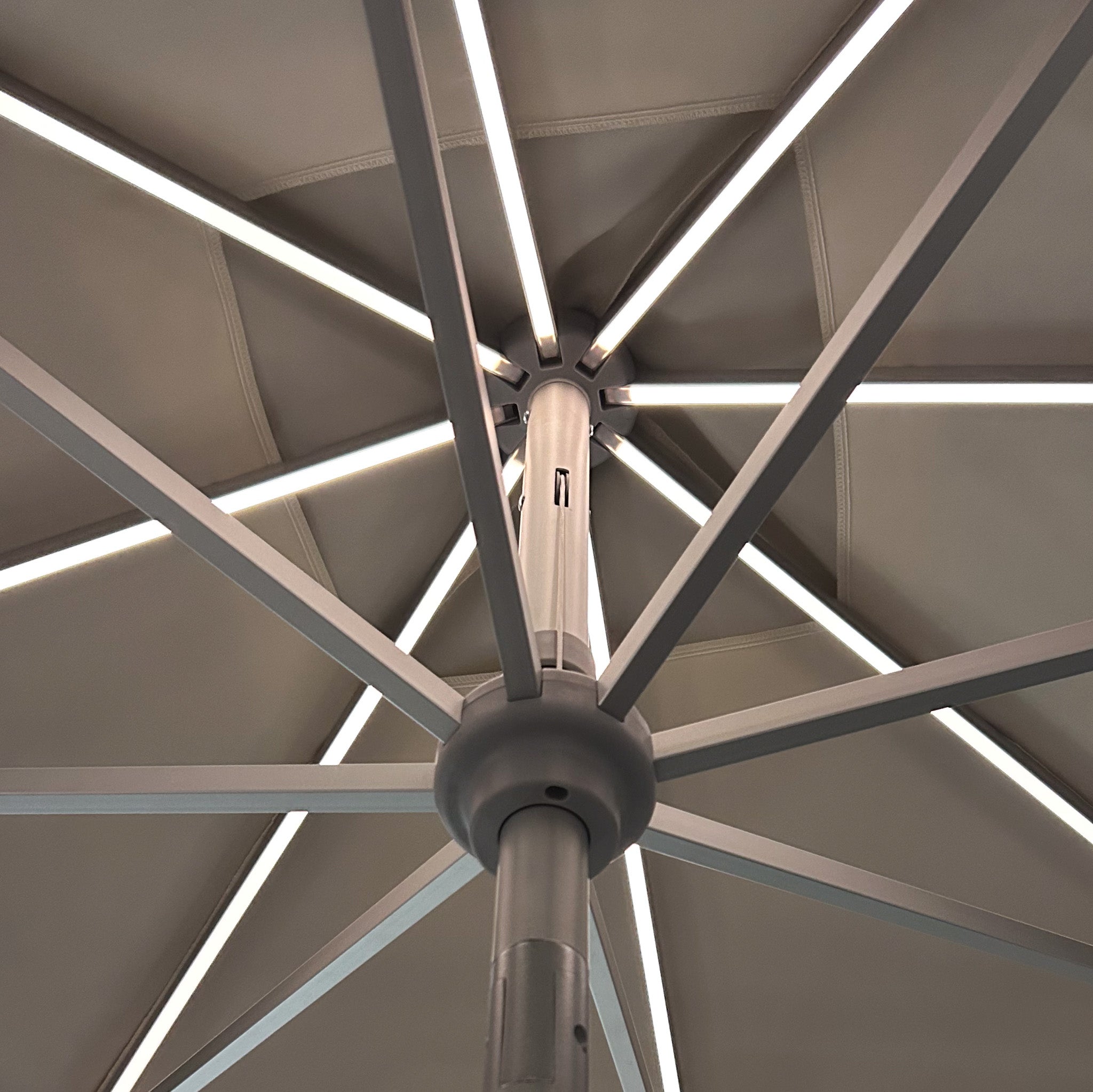 Close-up view of the underside of the Zelos 3m x 2m Rectangular Parasol in Cream, with LED-lit ribs forming a star pattern.