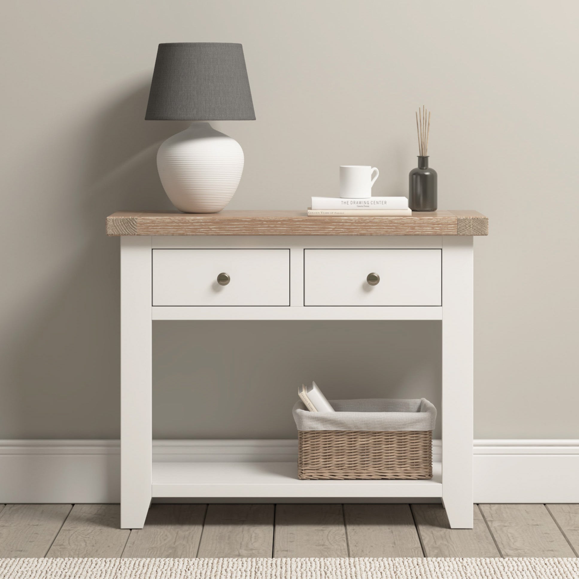 The Burford 2 Drawers Console Table in Warm White has two drawers, a natural oak top, and a lower shelf with space for storage.