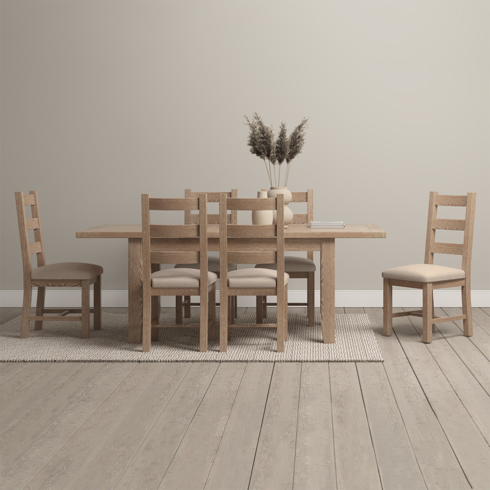 Explore a minimalist dining room showcasing the Burford 6 Seat Extending Dining Set in Natural Oak. This sophisticated wooden table is complemented by cushioned chairs placed on a neutral rug, while a vase of dried flowers enhances the tranquility of the space.