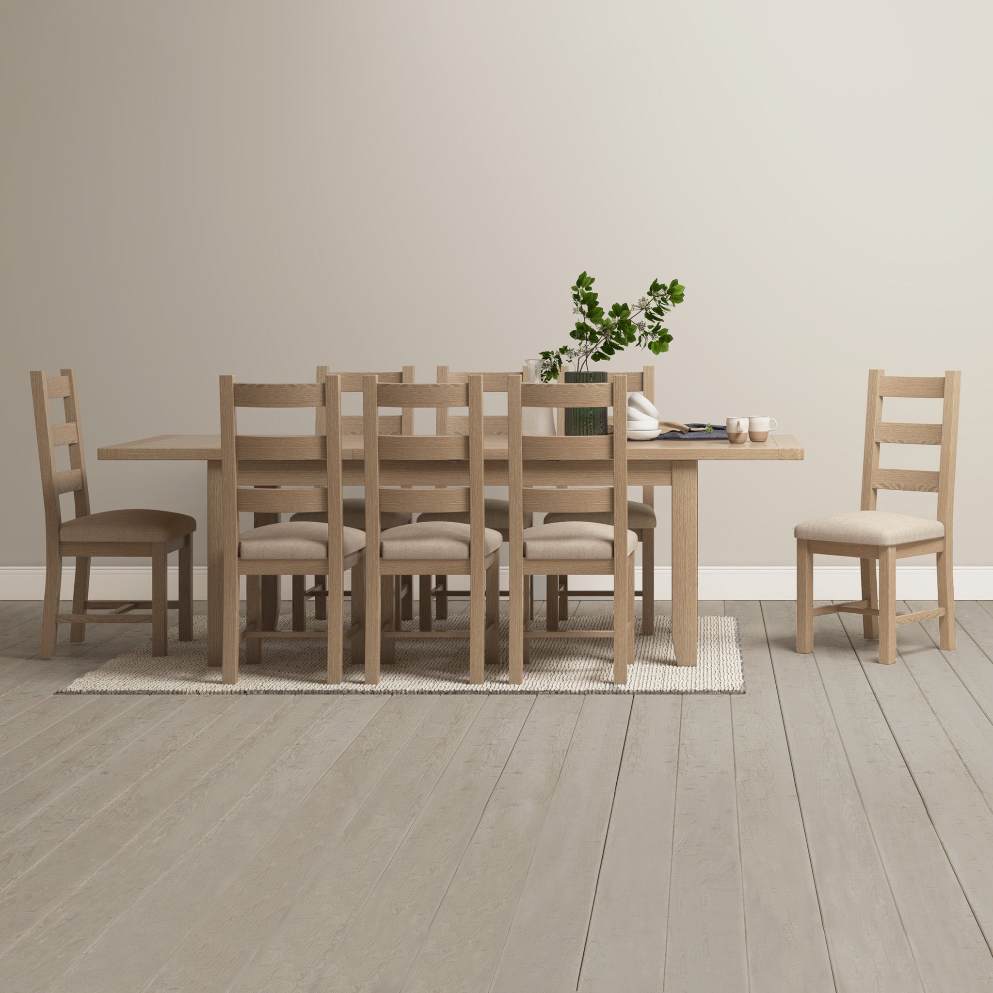 The Burford 8 Seat Extending Dining Set in Natural Oak enhances the arrangement of potted plants and books on a light-colored rug in the bright room.