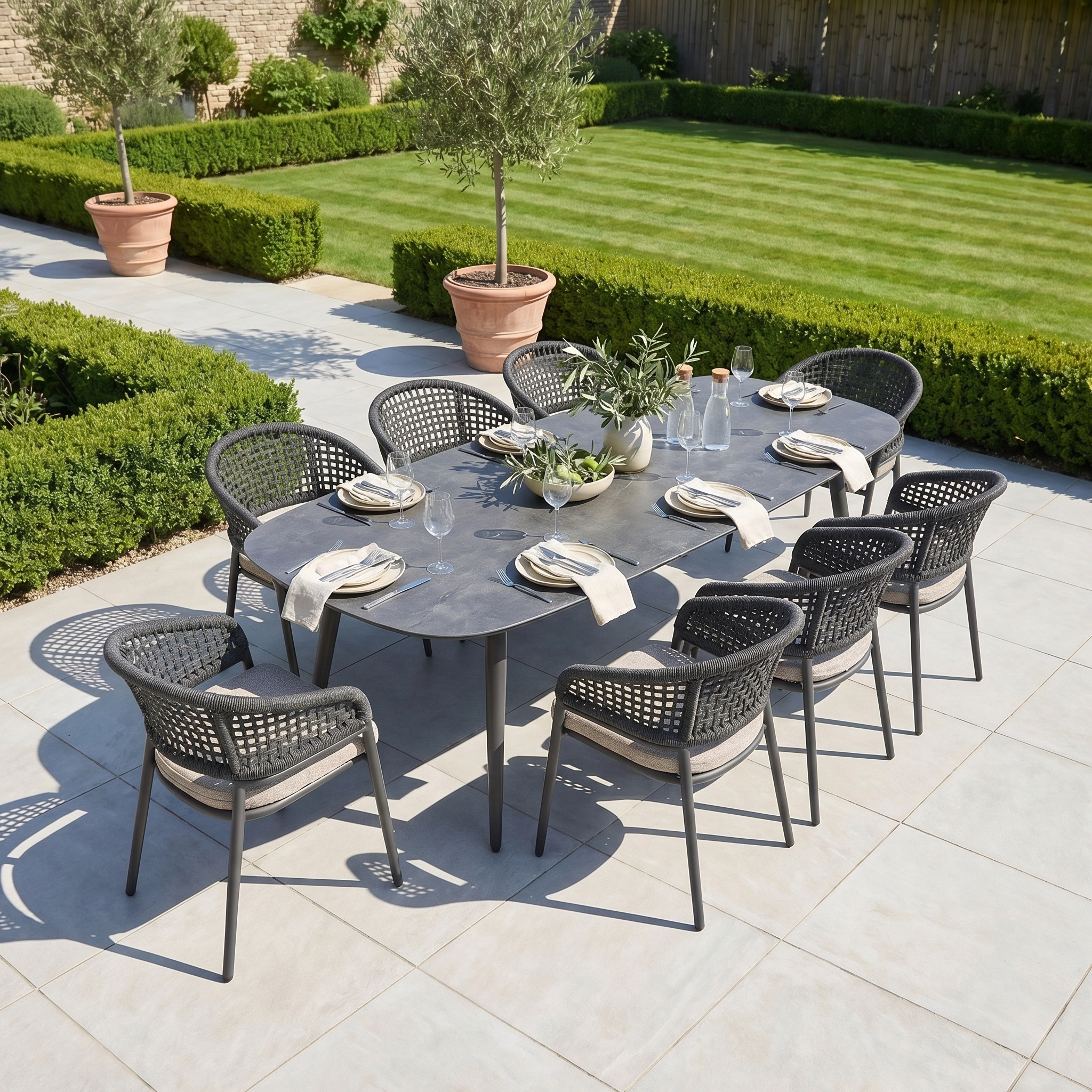 Enjoy outdoor meals with the Kalama 8 Seat Oval Rope Dining Set in Truffle—stylish garden furniture with woven chairs, perfect for entertaining guests on your patio surrounded by greenery.