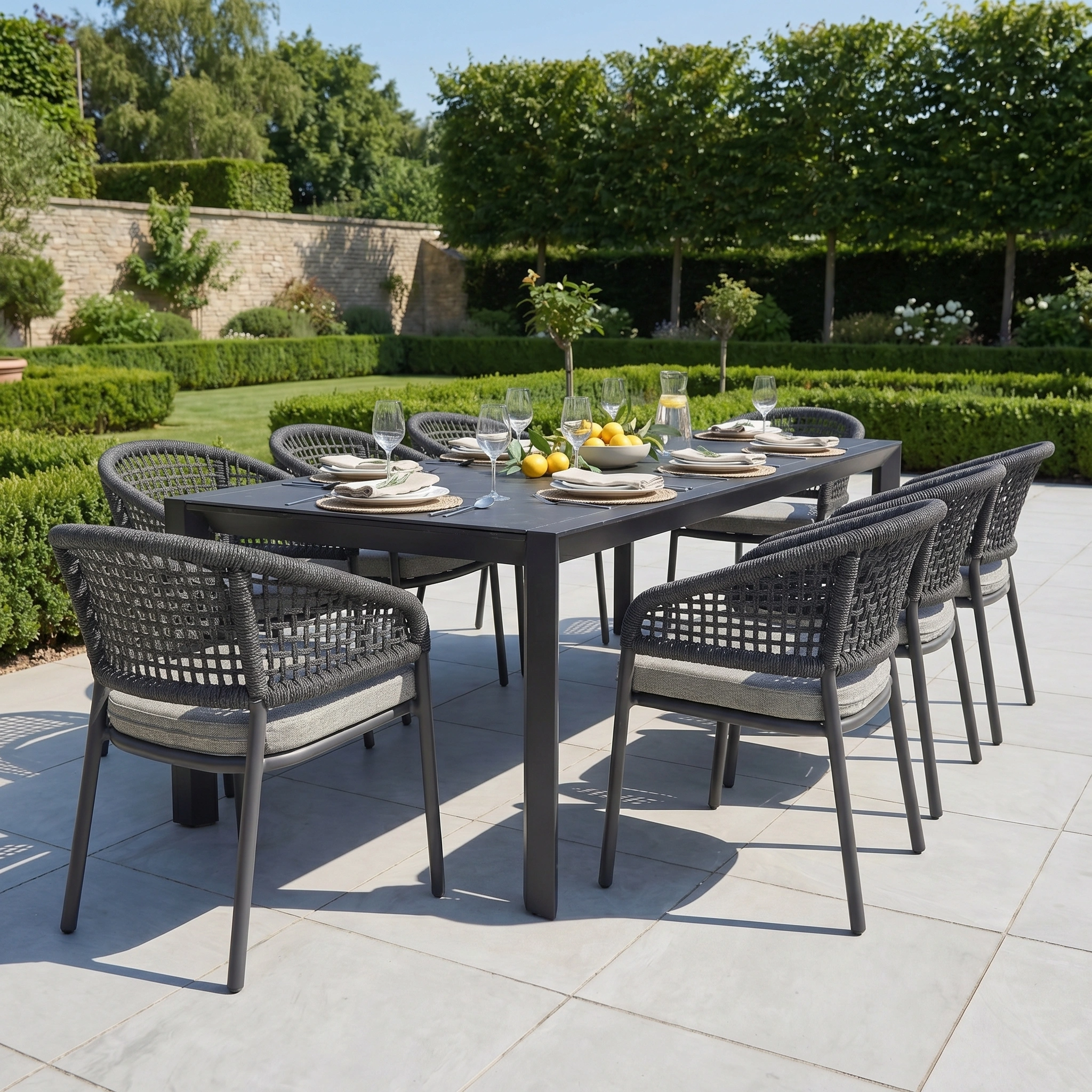 The Kalama 8 Seat Extending Dining Set with Ceramic Table in Truffle features eight chairs and a stylish ceramic table, perfect for outdoor dining in a charming garden patio setting.