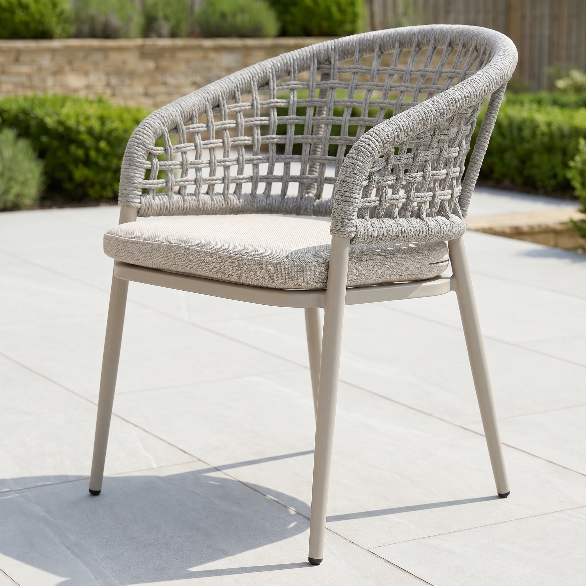 The Kalama 6 Seat Oval Rope Dining Set in Oatmeal features modern chairs with woven backrests and cushioned seats, ideal for elevating your garden furniture on a tiled patio.